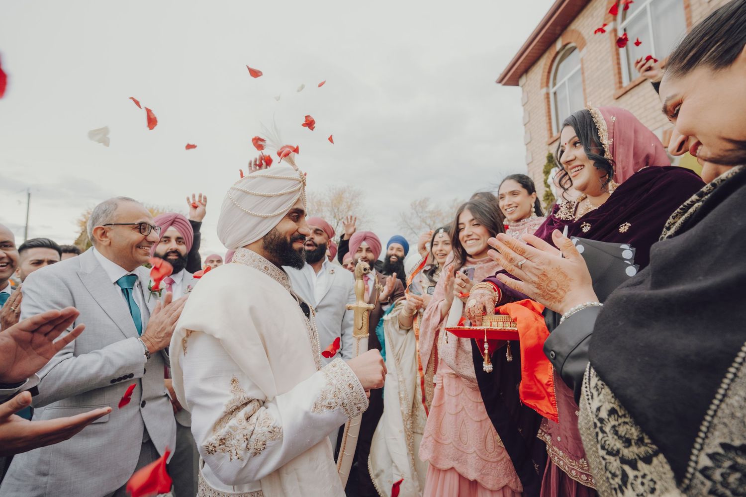 Wedding guests celebrating with rose petals during a joyous ceremony exit.