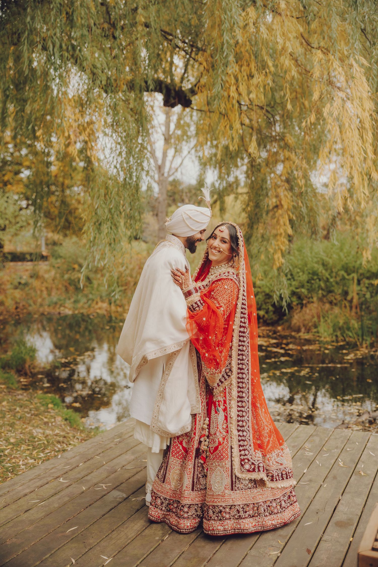 Autumn wedding photography session on a wooden deck surrounded by willow trees.