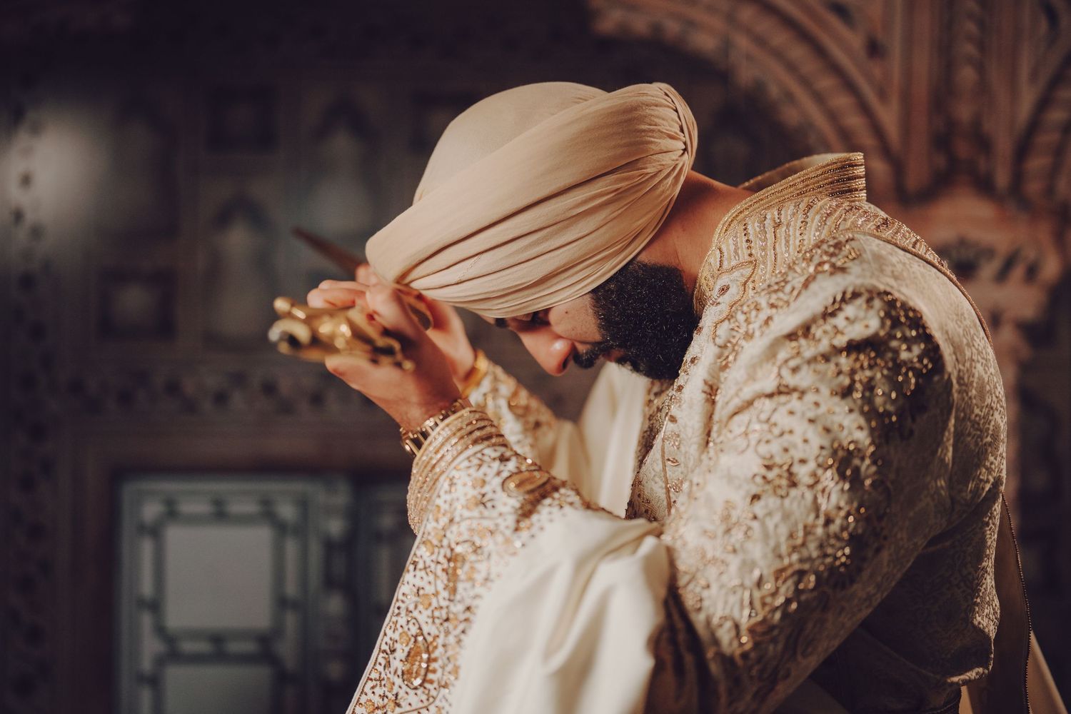 Wedding ceremony participants in traditional attire against an ornate architectural backdrop.