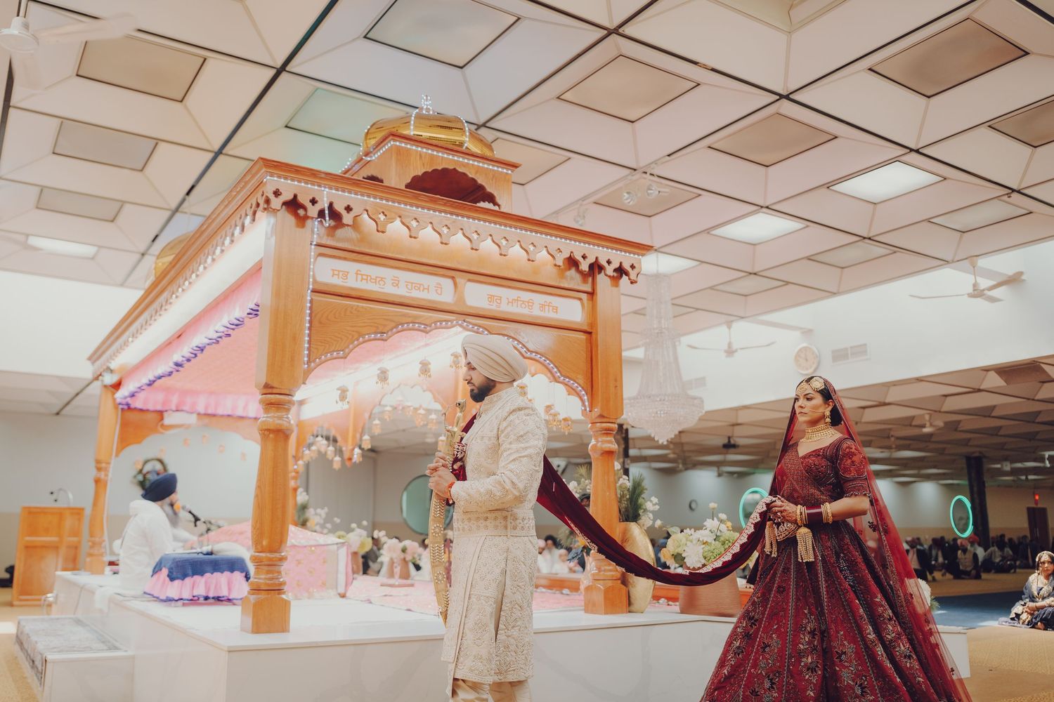 Wedding venue interior decorated with arches and traditional elements for a Sikh ceremony.