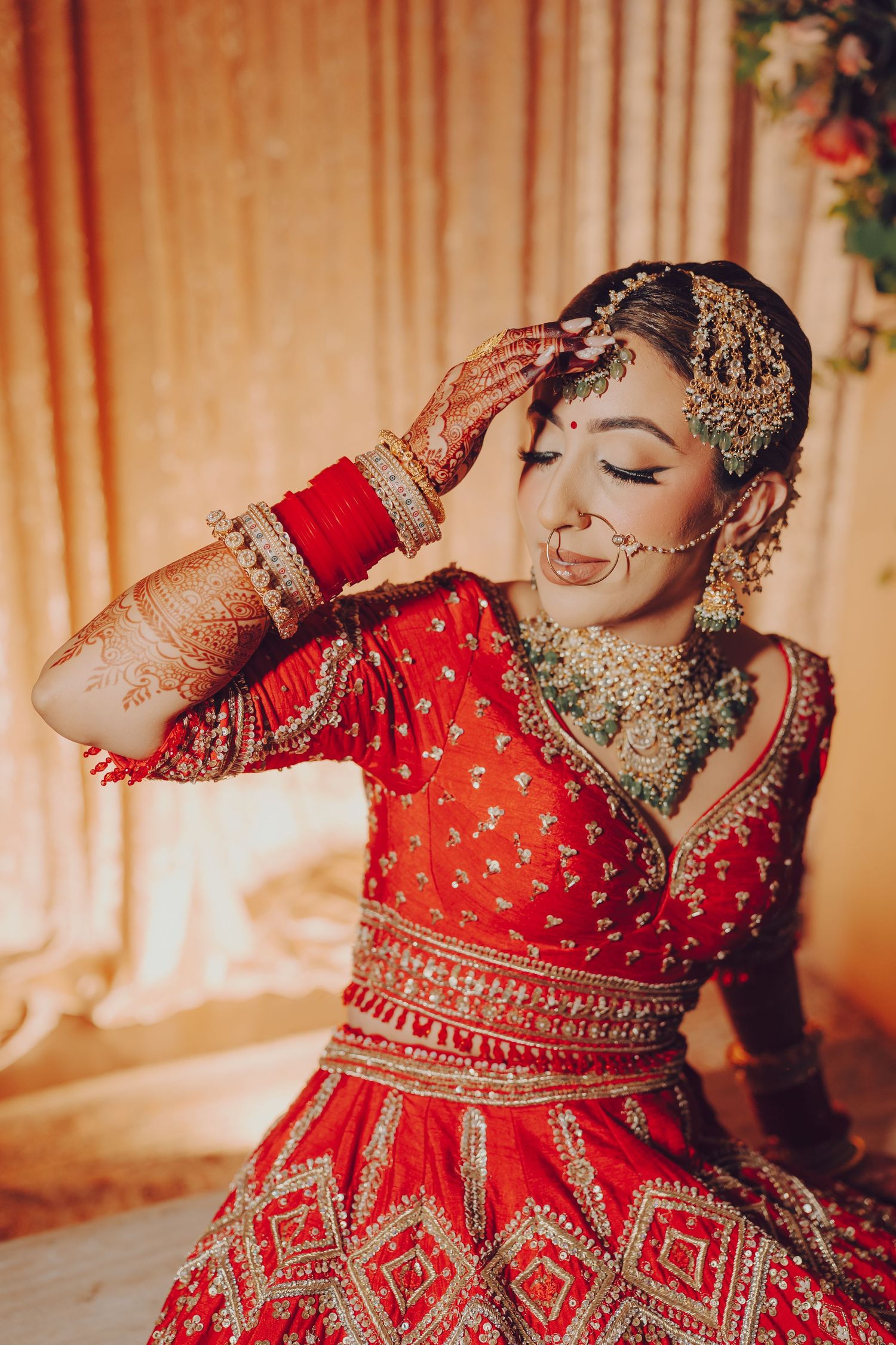 Detailed shots of an ornate red and gold embroidered Indian bridal lehenga with intricate traditional designs.