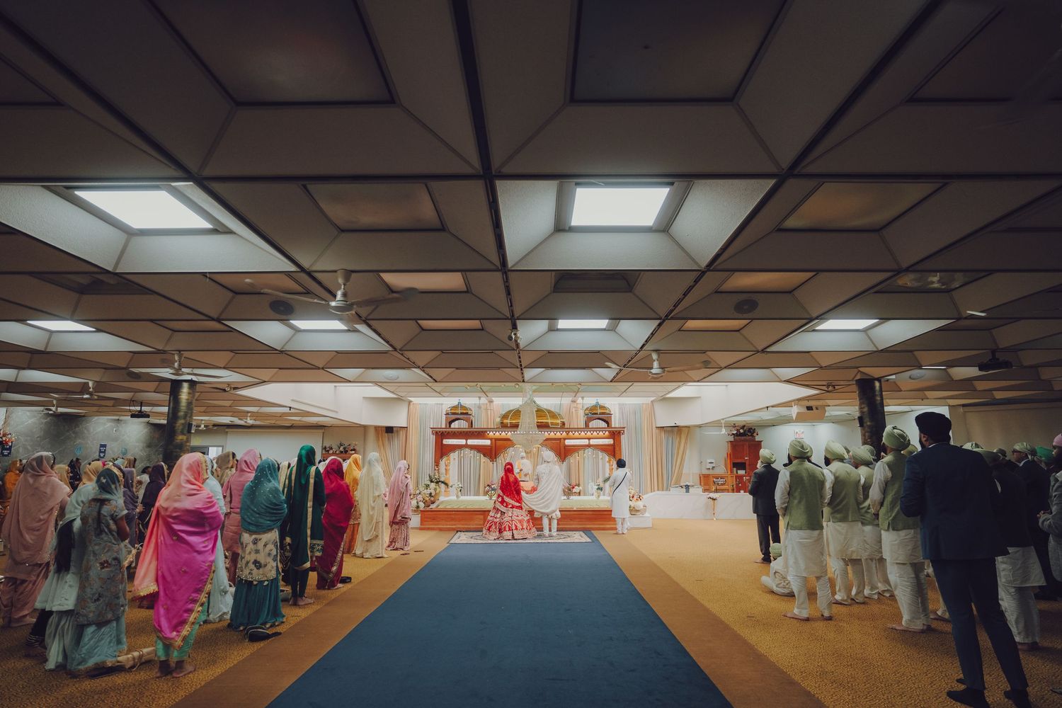 Interior panorama of a wedding venue with fluorescent lighting and suspended ceiling tiles.