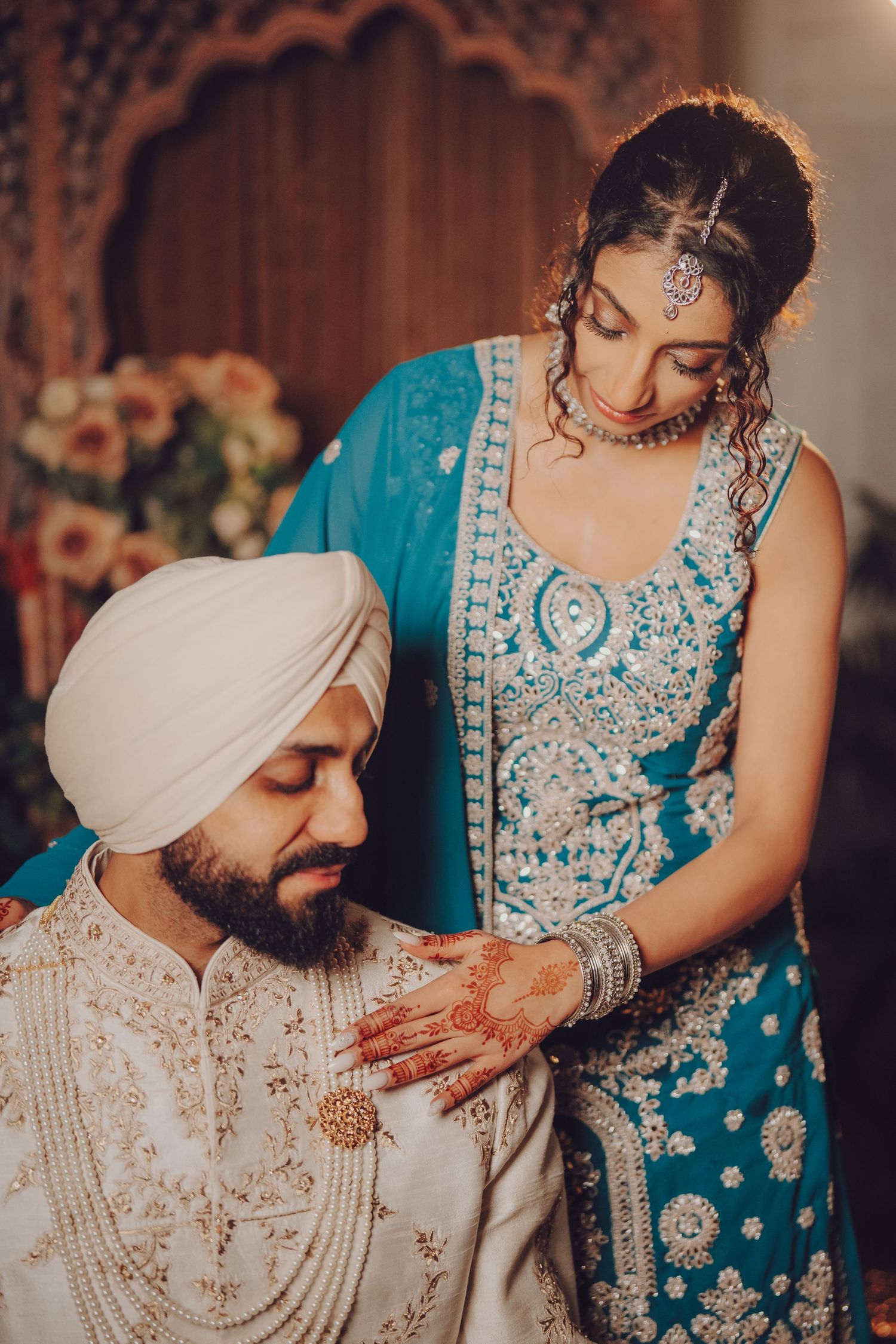 Traditional Sikh wedding ceremony detail with turquoise and white embellished attire.