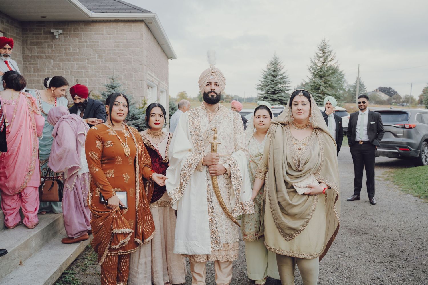 Traditional Sikh wedding ceremony guests gathered outside in formal ethnic attire.