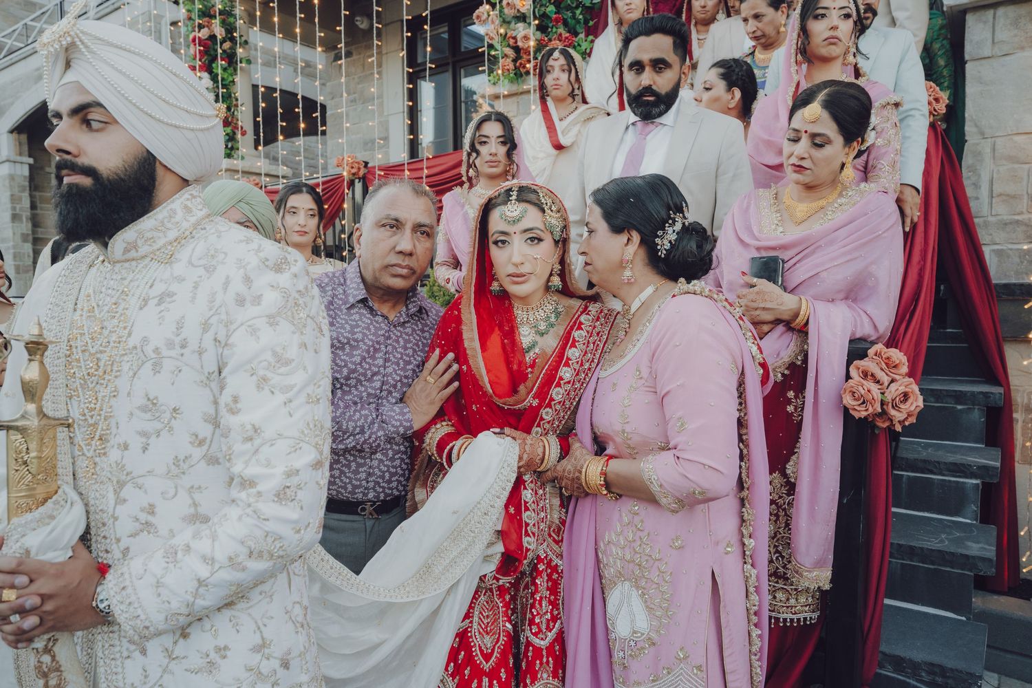 Wedding celebration with guests in traditional attire gathered outside.