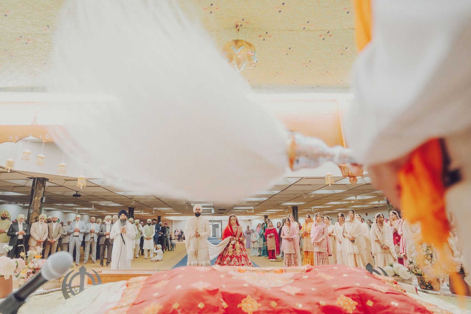 Outdoor wedding celebration with colorful smoke effects and guests gathered in scenic mountain landscape.