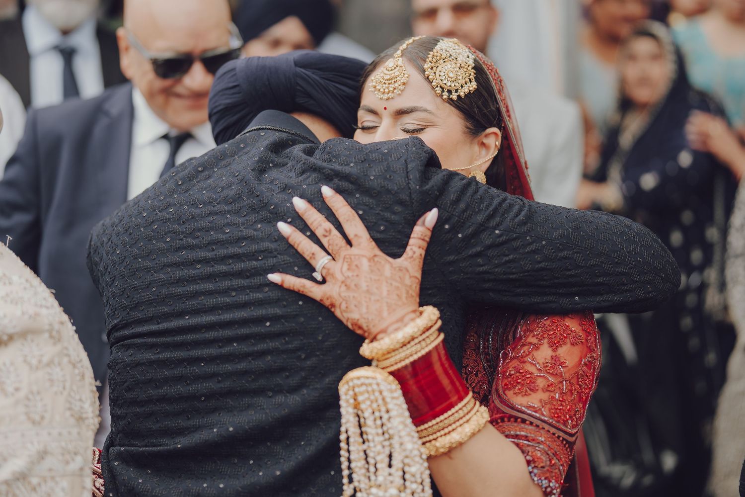 Emotional wedding moment captured during traditional Sikh ceremony.