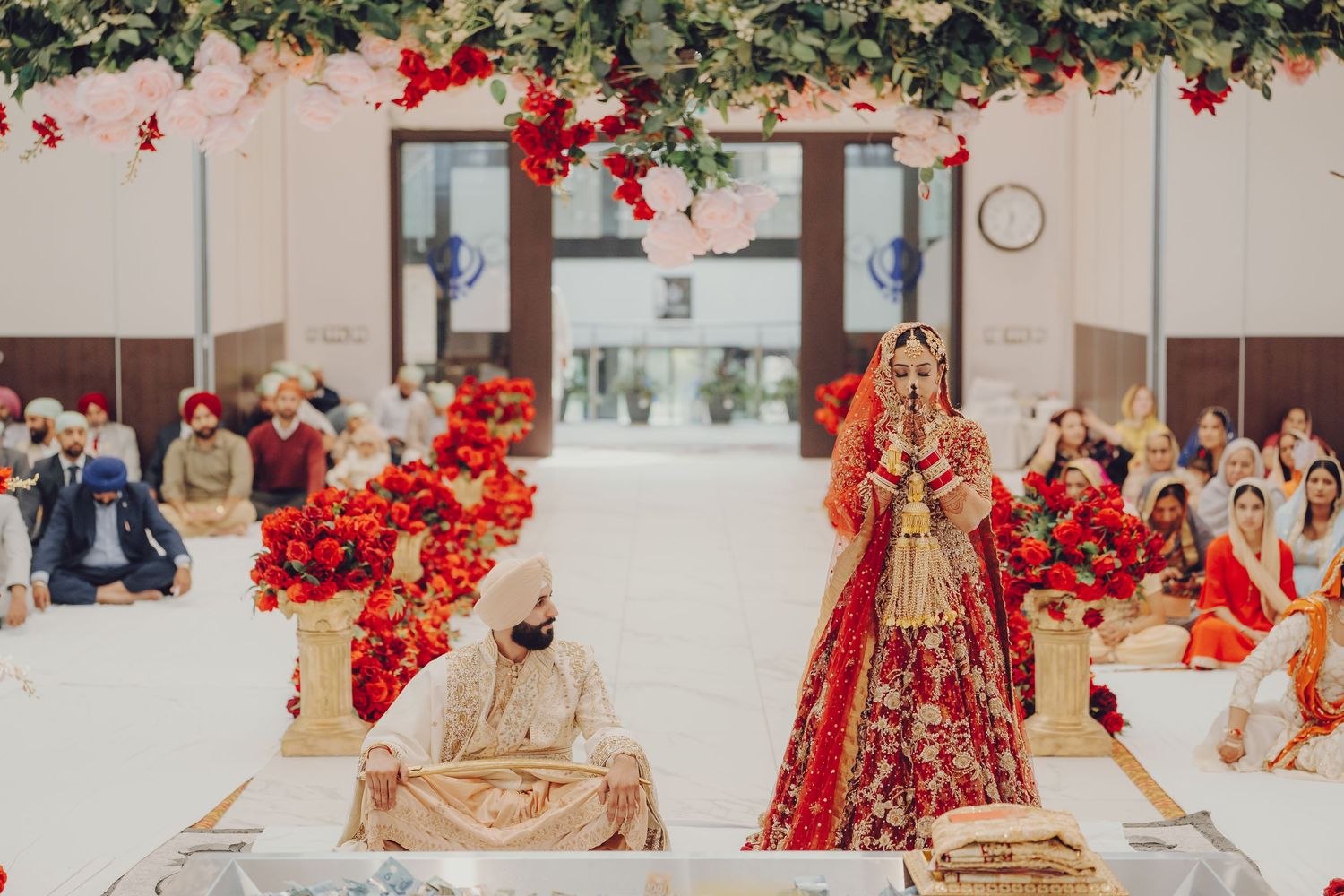 Traditional Indian wedding ceremony setup with red floral decorations and elegant mandap stage for the celebration.