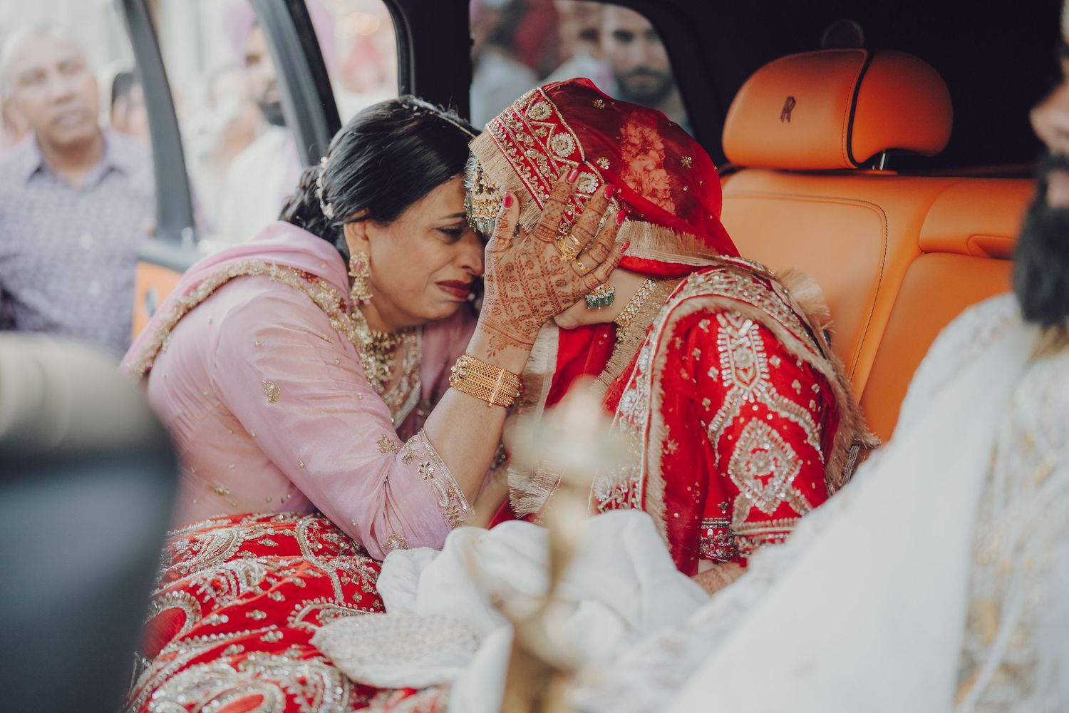 Wedding ceremony guests in traditional Indian attire sharing emotional moments during the celebration.