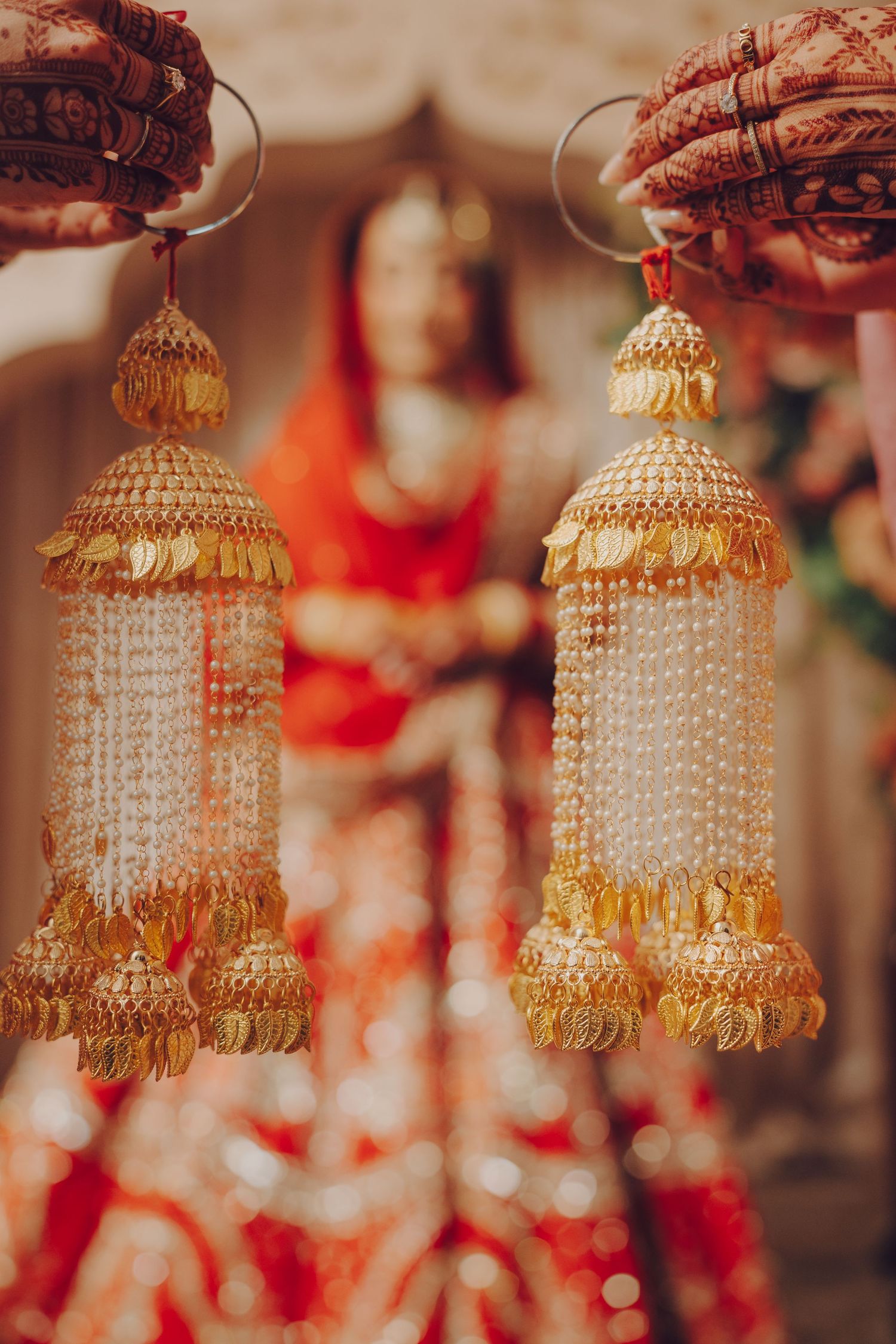 Ornate gold and pearl kalire hanging decorations with crystal beads displayed at an Indian wedding.