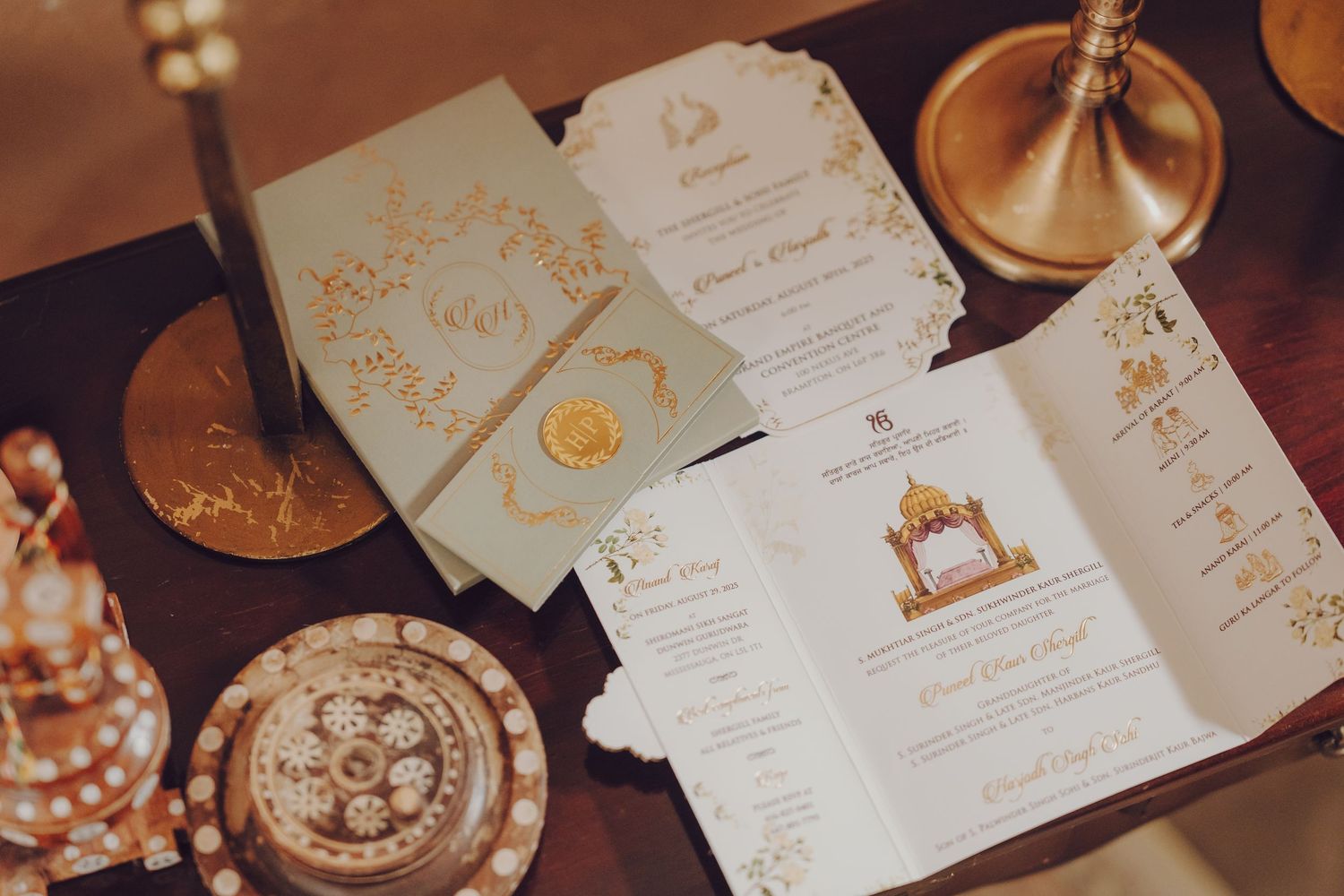 Elegant wedding invitation cards and decorative elements arranged on a rustic wooden surface with warm lighting.