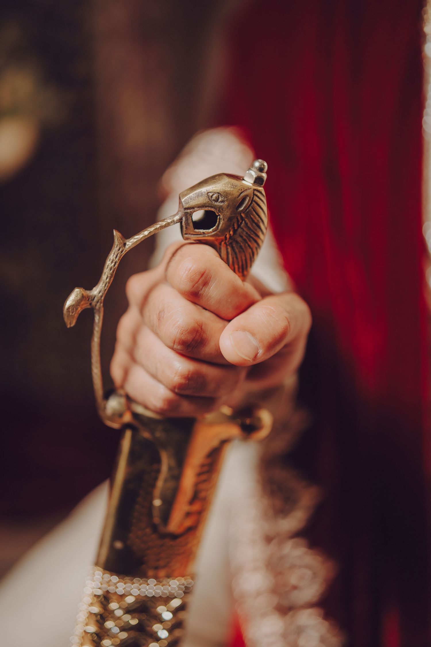 Close-up shot of hands holding ornate ceremonial items during a traditional wedding ritual.