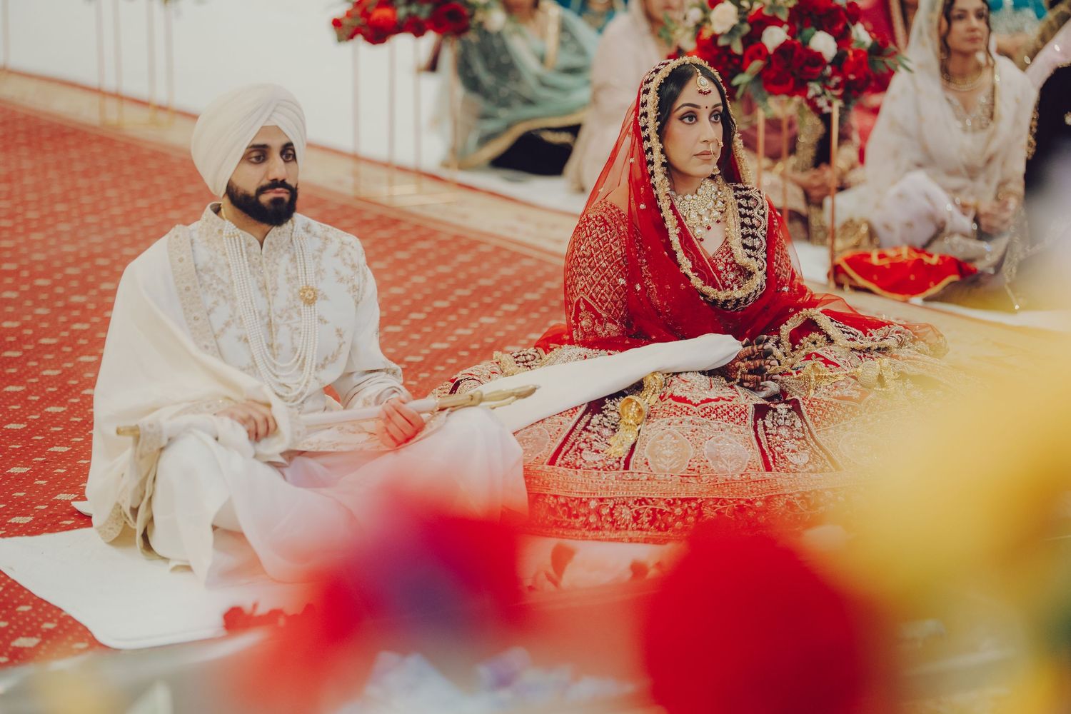 Traditional Sikh wedding ceremony with red and white decorative elements.