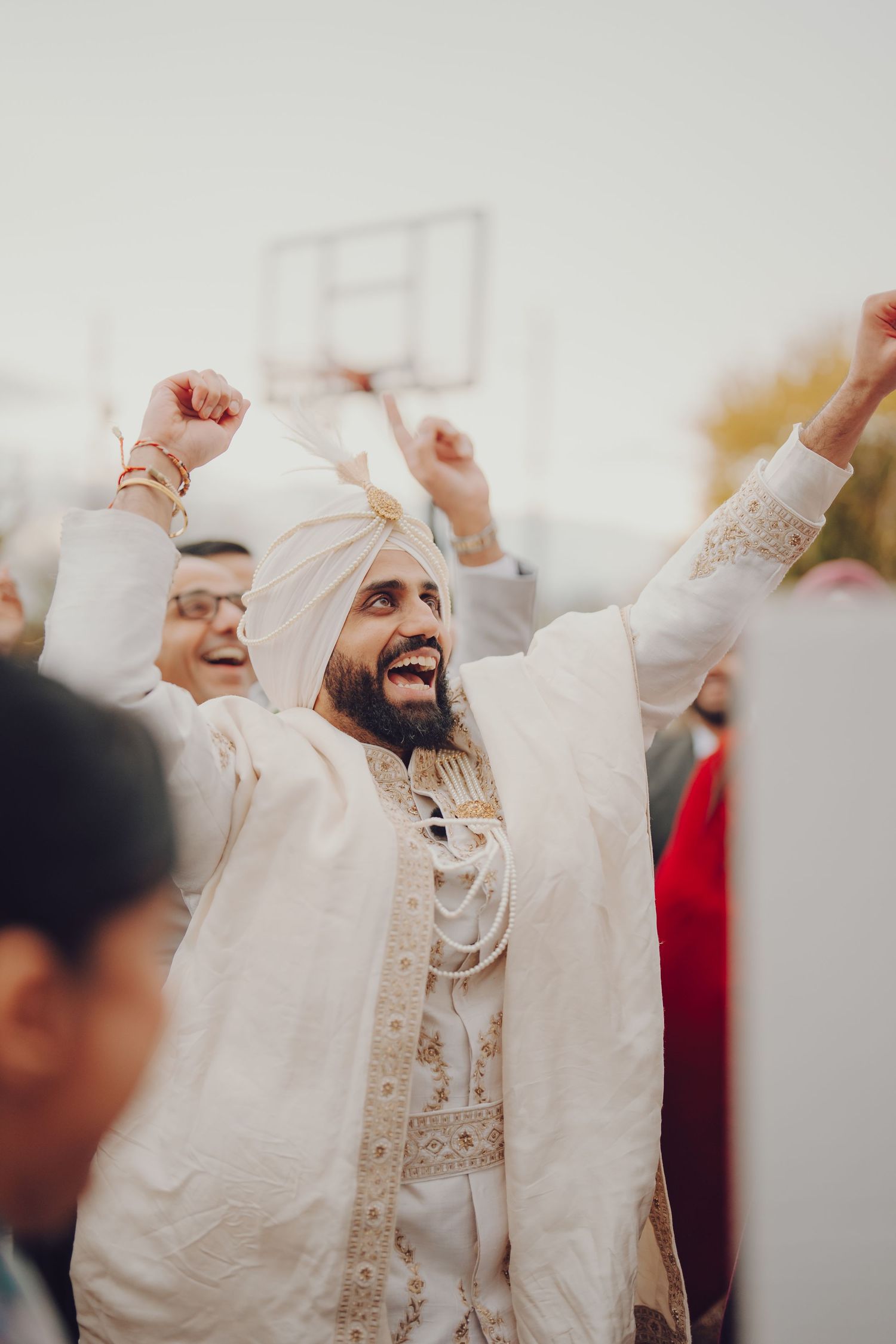 Wedding celebration with guests in traditional Sikh attire showing joyful expressions.