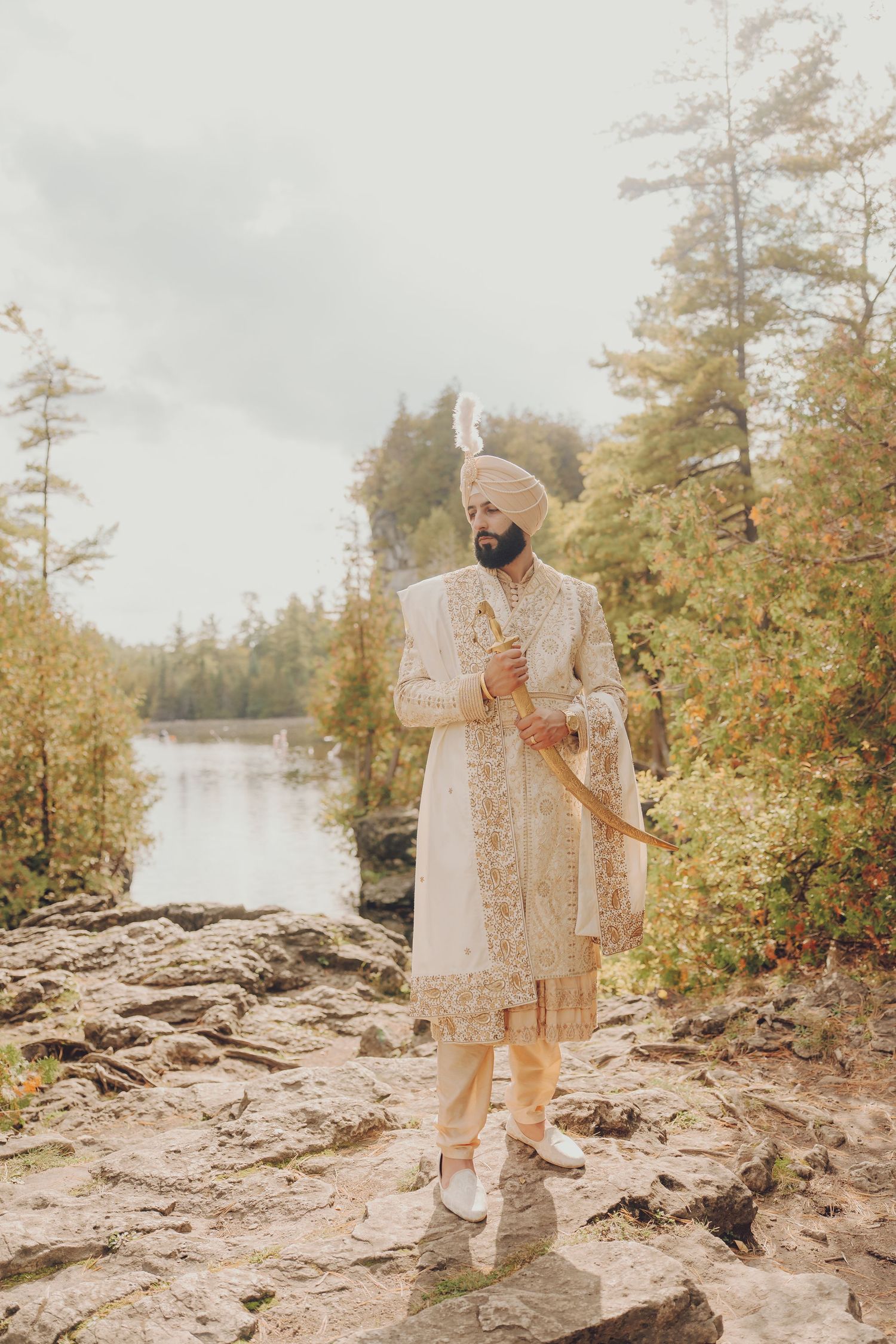 Elegant wedding photography session on rocky terrain near a serene lake.