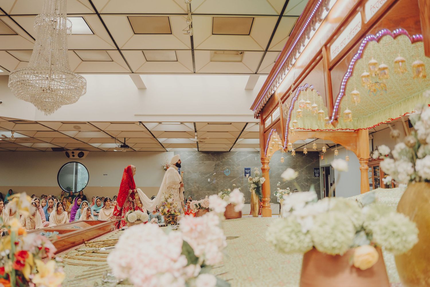 Interior view of decorated wedding venue with ornate ceiling and lighting features.