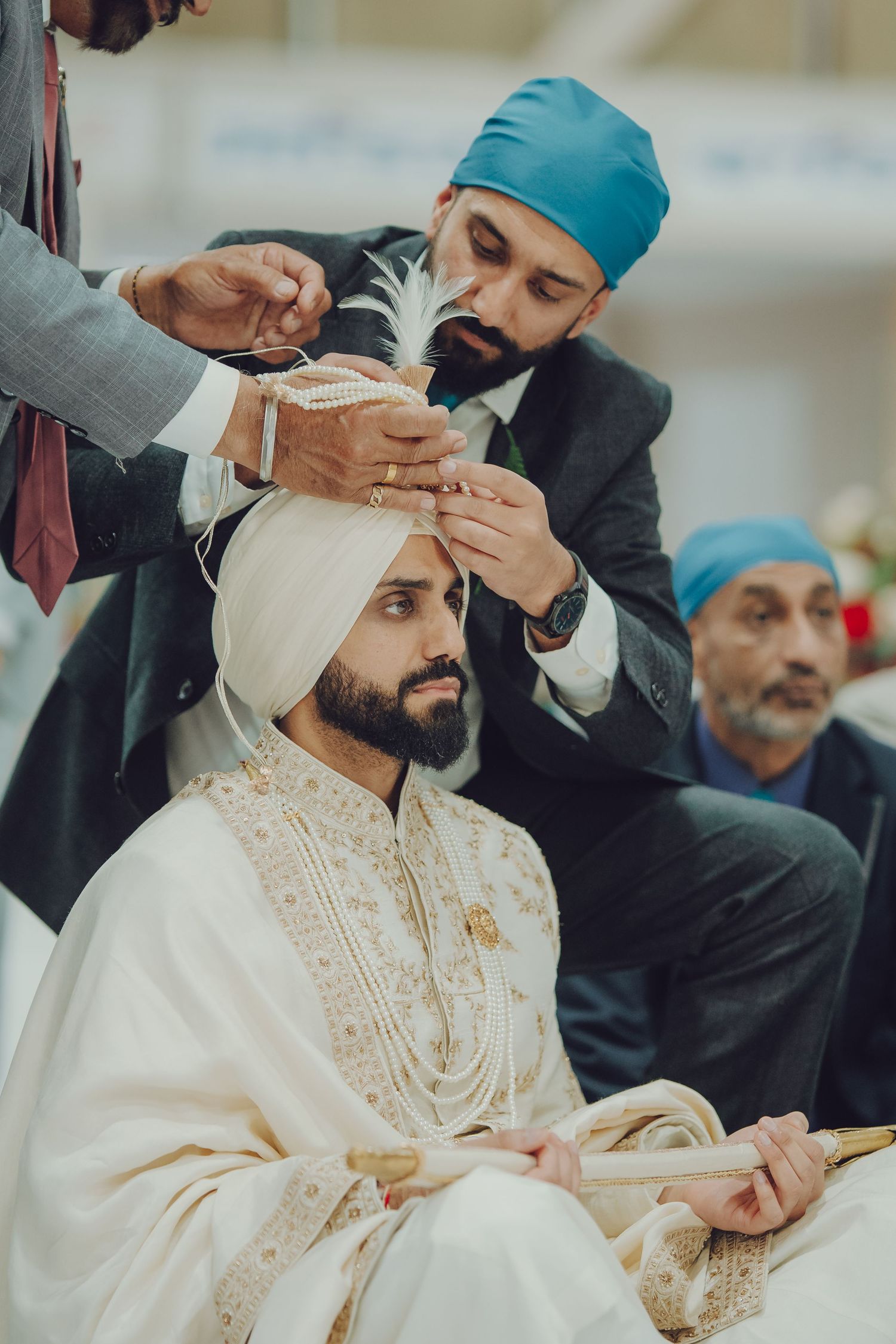 A sequence of four photos showing a traditional Sikh turban tying ceremony with a person wearing white attire.