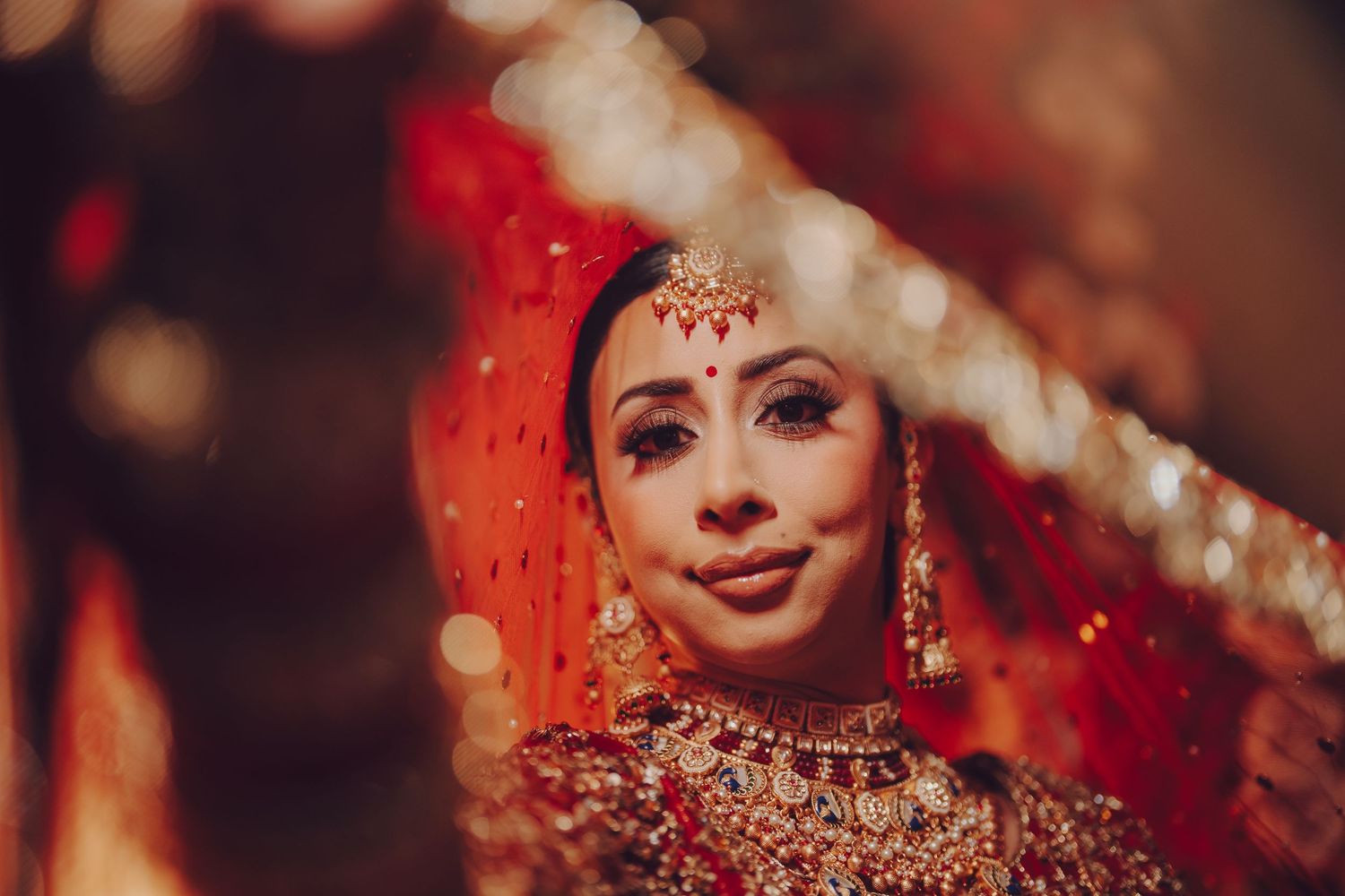 Close-up shots of intricate bridal jewelry and makeup details with warm bokeh lighting effects.