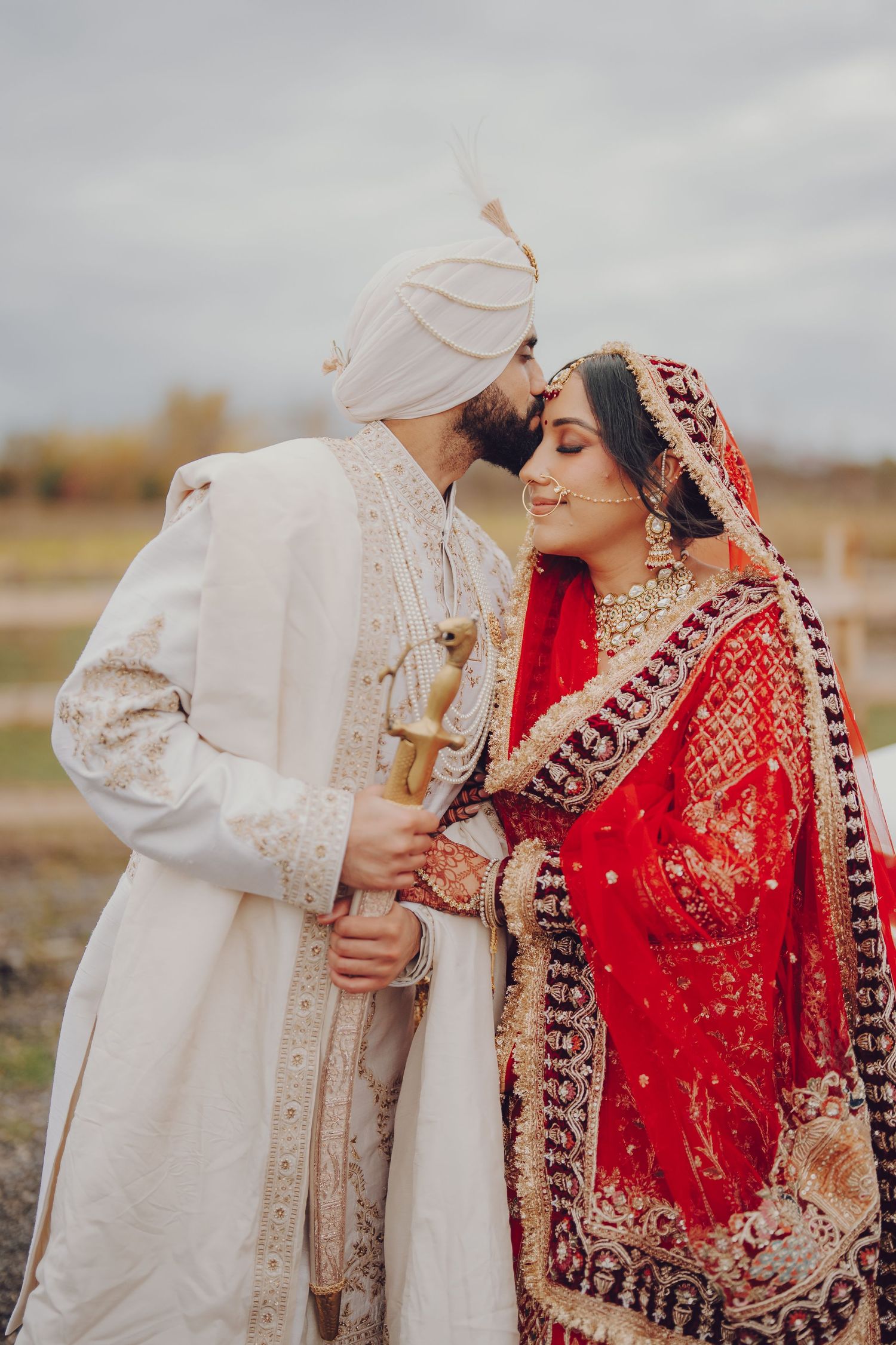 Romantic outdoor wedding photography session featuring traditional Indian wedding attire.