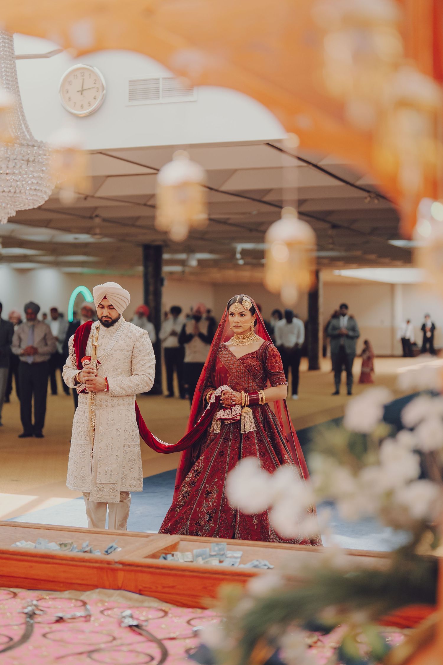 Sikh wedding couple in traditional attire standing during ceremony.
