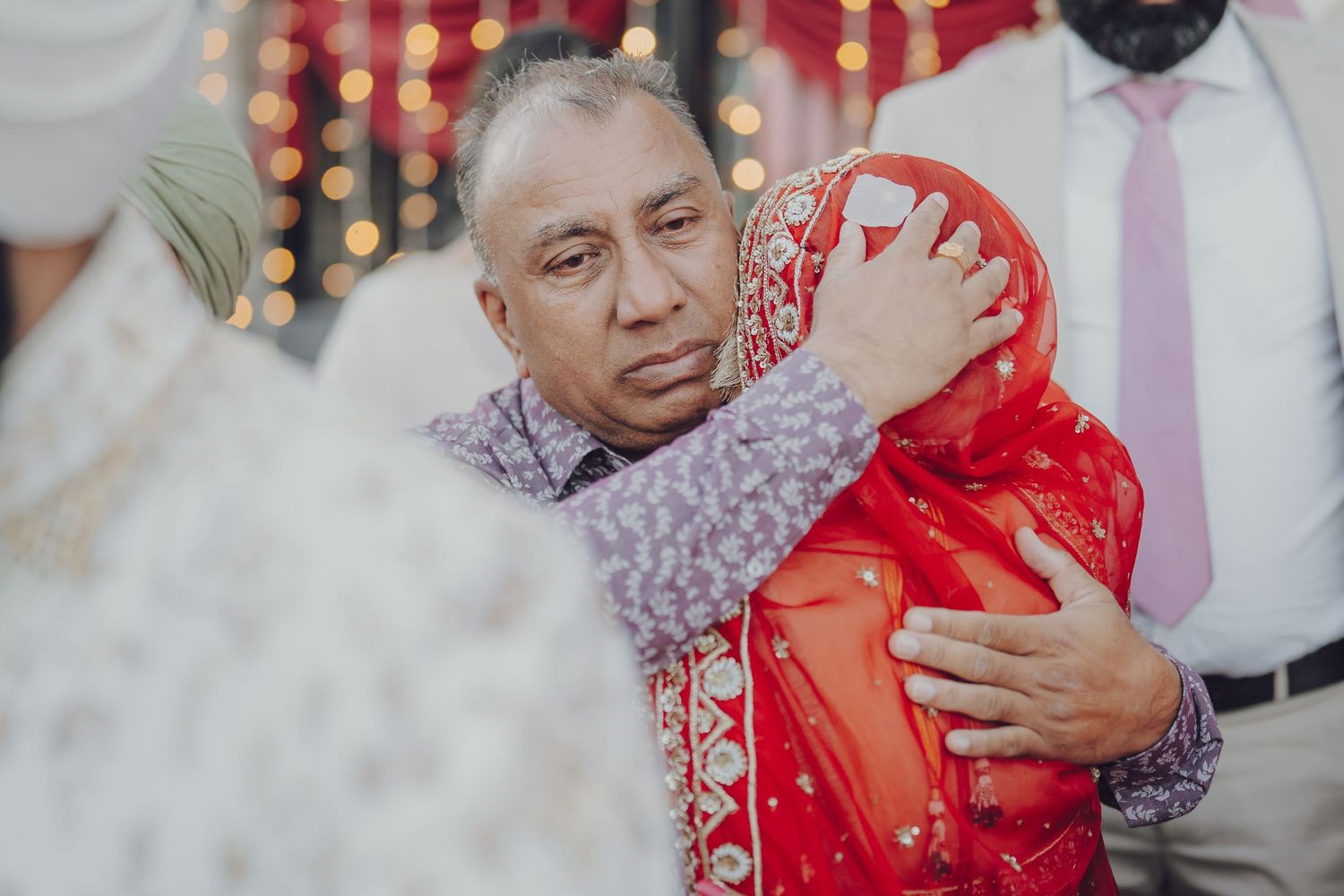 An emotional moment during a wedding ceremony with guests embracing.