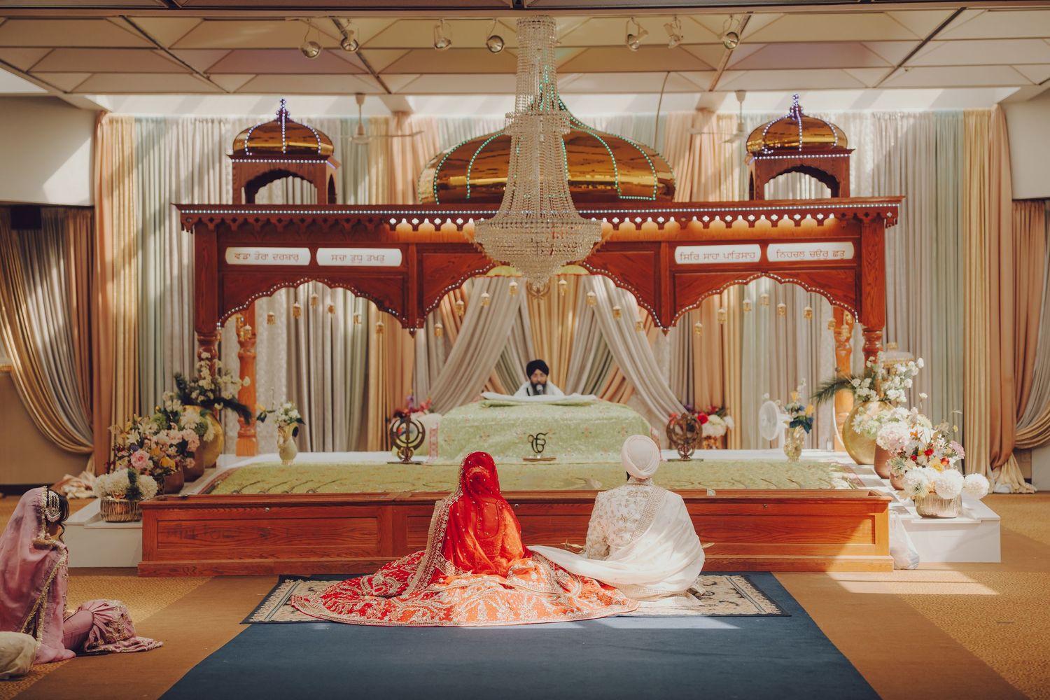 Wide view of traditional Sikh wedding ceremony setup with decorative mandap and seating arrangements.