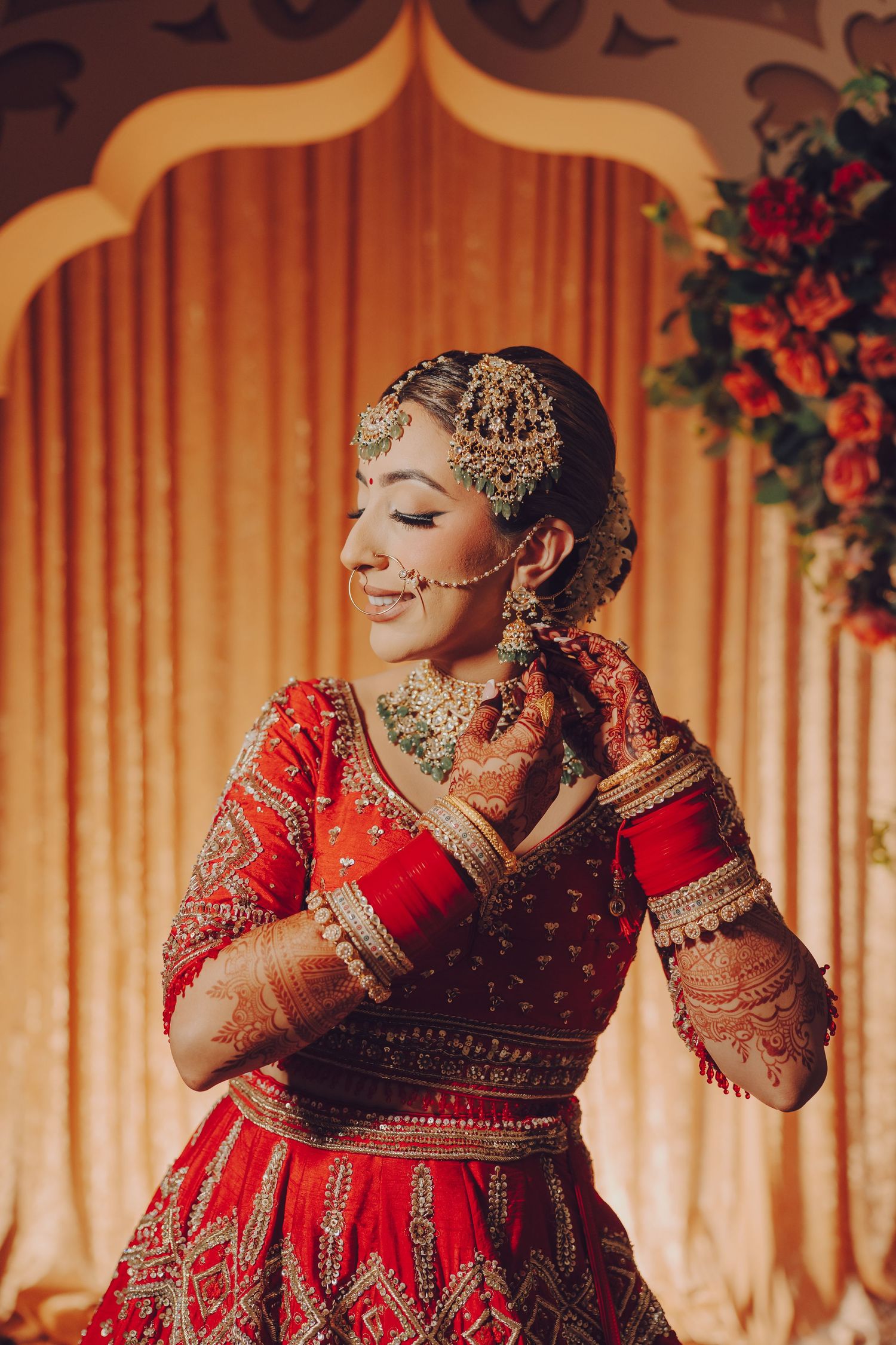 Traditional Indian bridal jewelry and makeup details shown in warm golden lighting at a wedding ceremony.