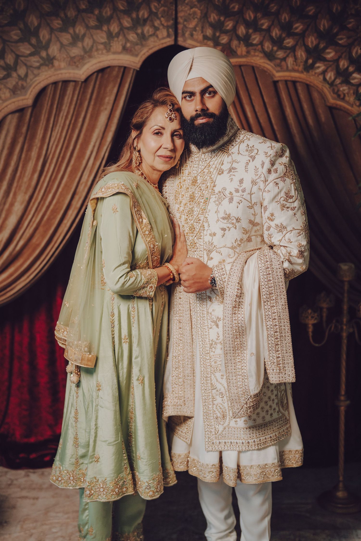 Traditional Indian wedding attire featuring mint green and cream colored outfits with detailed embroidery.