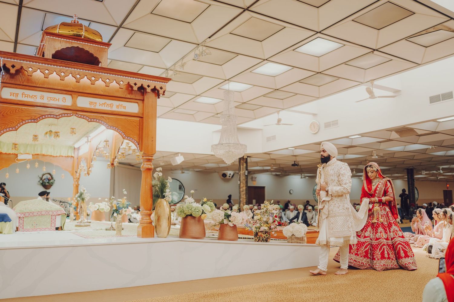 Interior view of a large wedding hall with guests seated for a traditional ceremony.