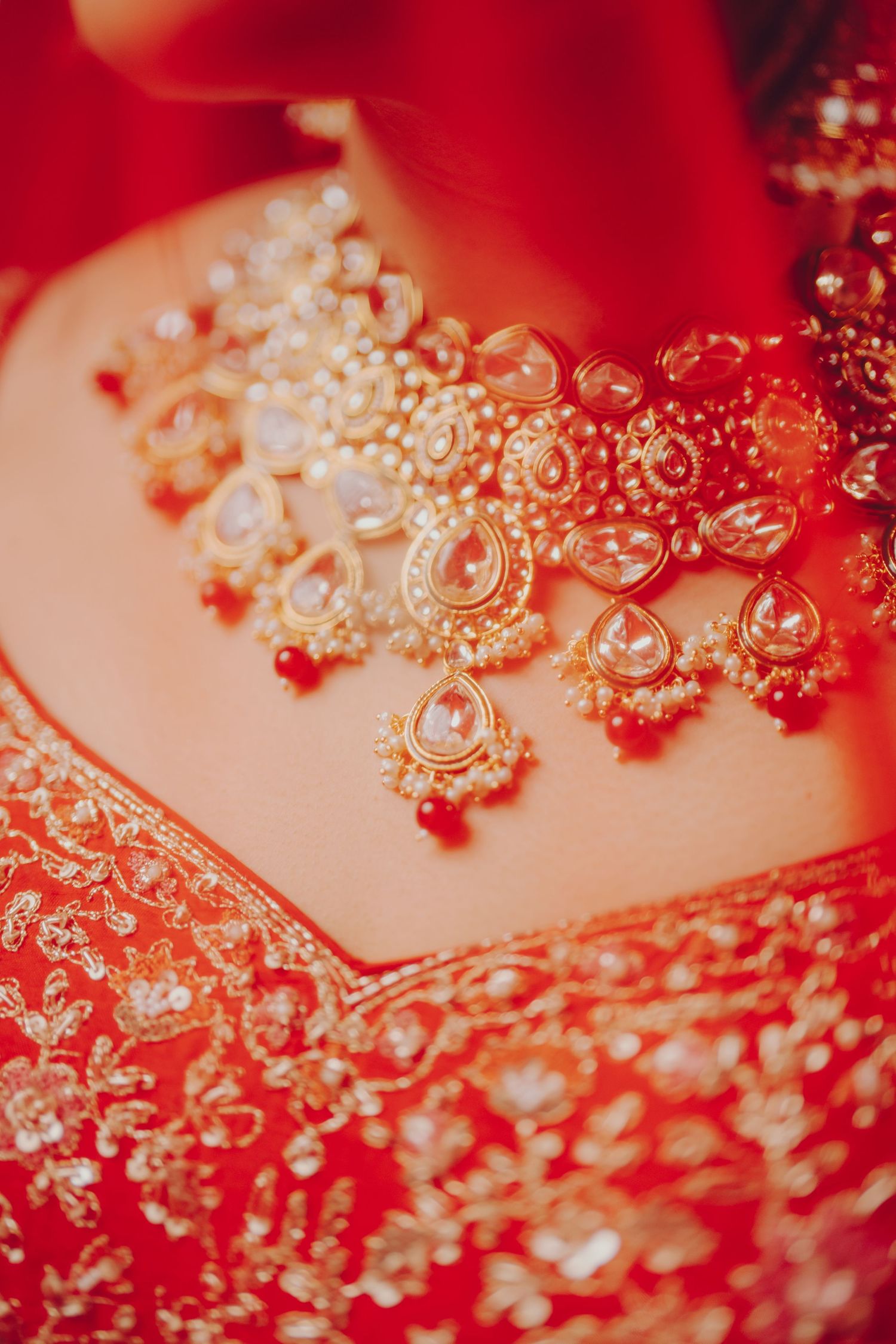 Intricate red and gold embroidered Indian wedding attire with detailed beadwork.