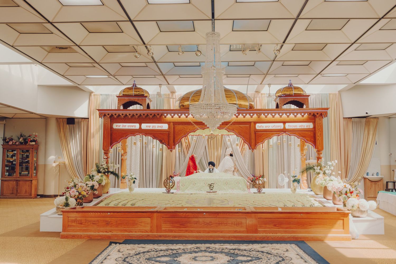 Panoramic view of a decorated wedding hall with traditional ceremonial setup.