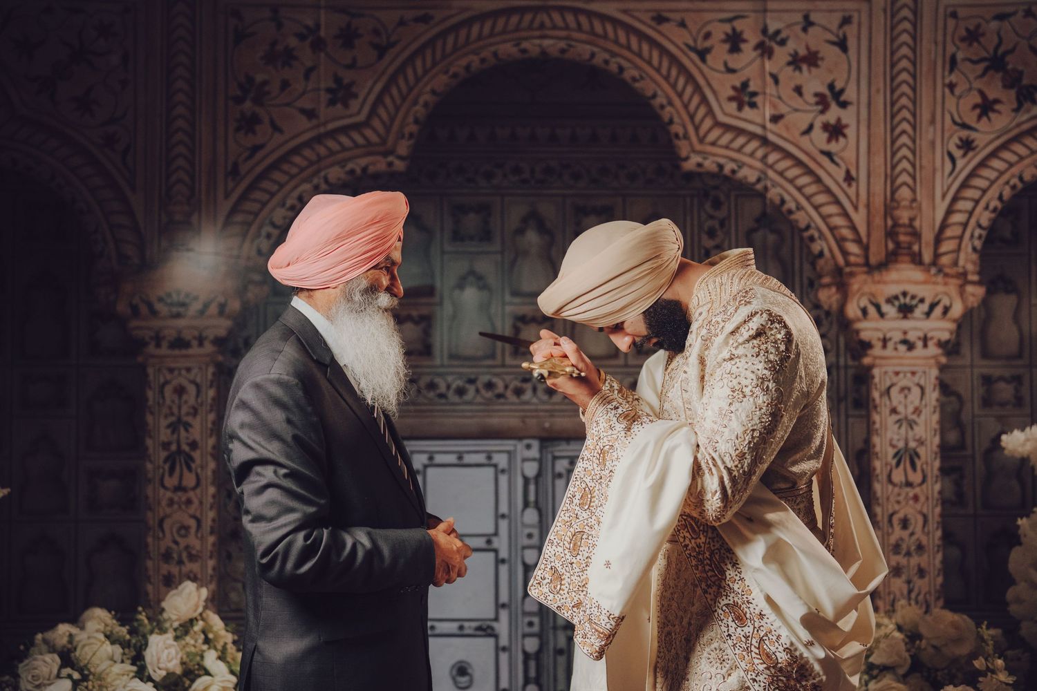 Intimate wedding moment captured in front of detailed architectural arches and designs.