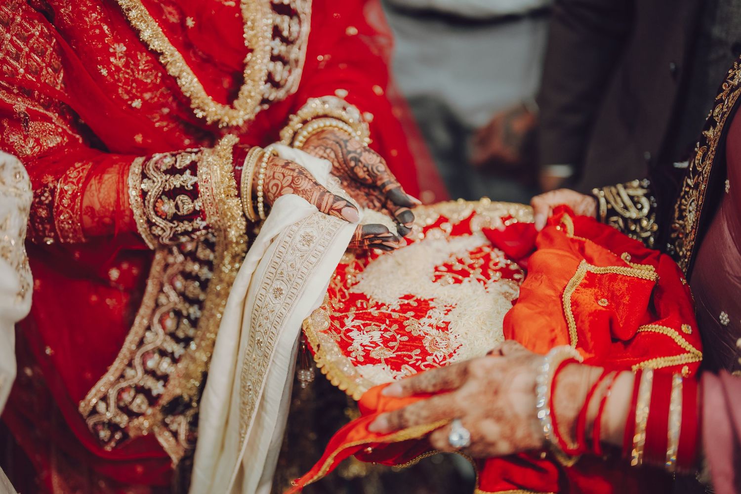 Close-up of traditional Indian wedding ceremony rituals with red and gold details.