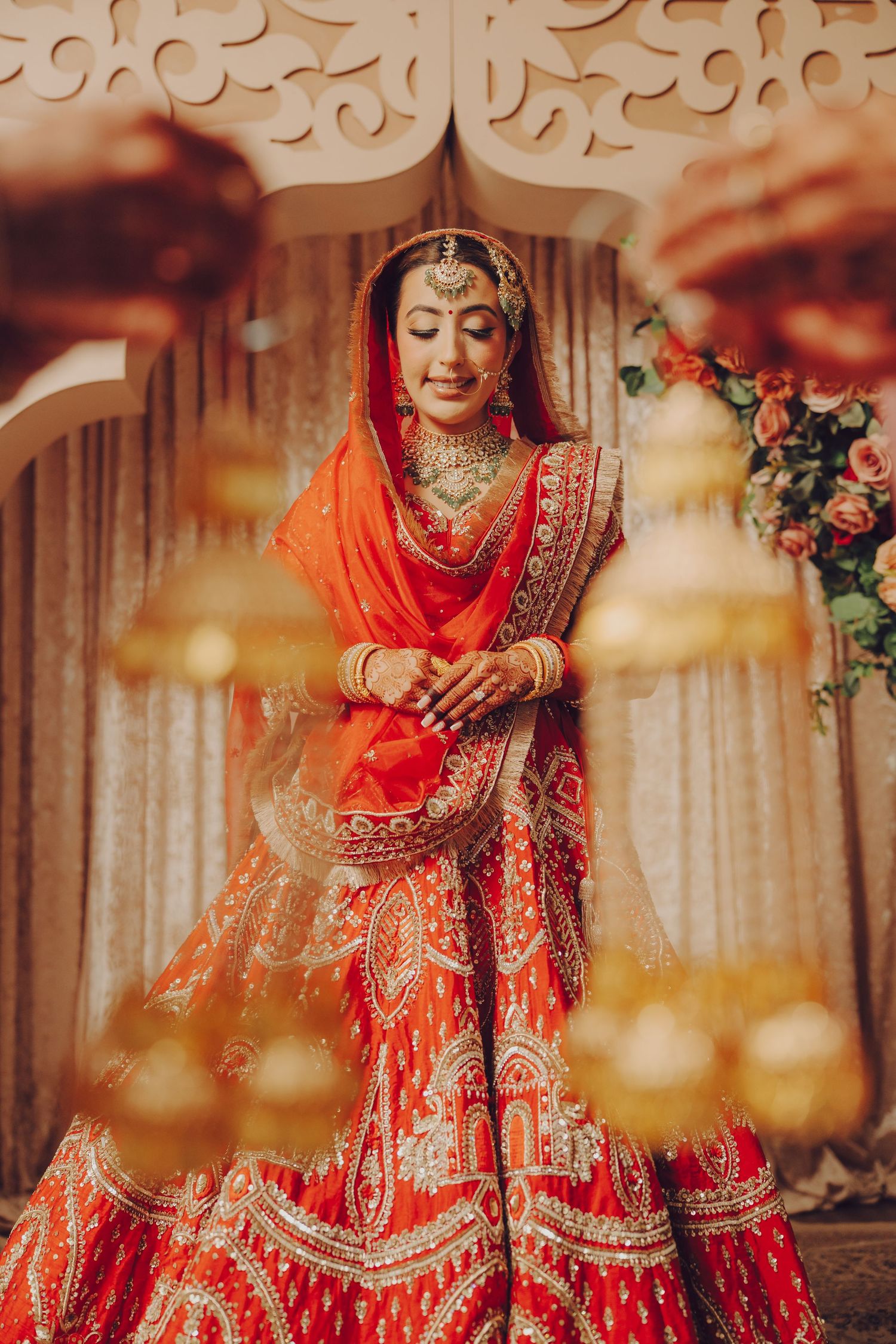 Stunning red and gold bridal lehenga captured in artistic wedding photography.