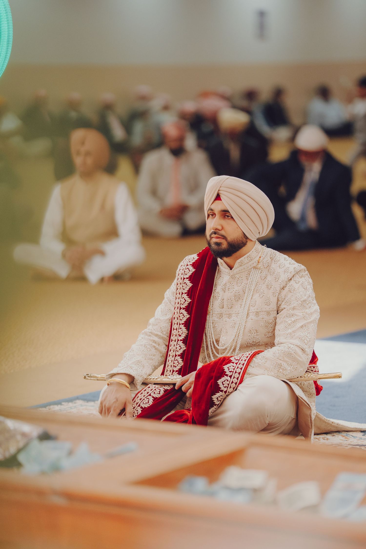 Traditional Sikh wedding ceremony with groom seated in prayer position.