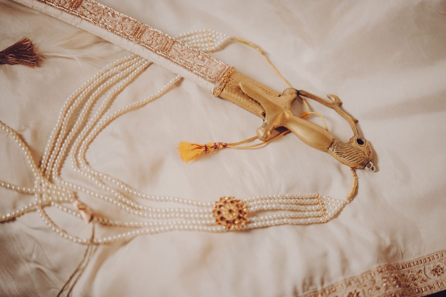 Delicate gold chain necklaces with bamboo style links laid out on white fabric texture.