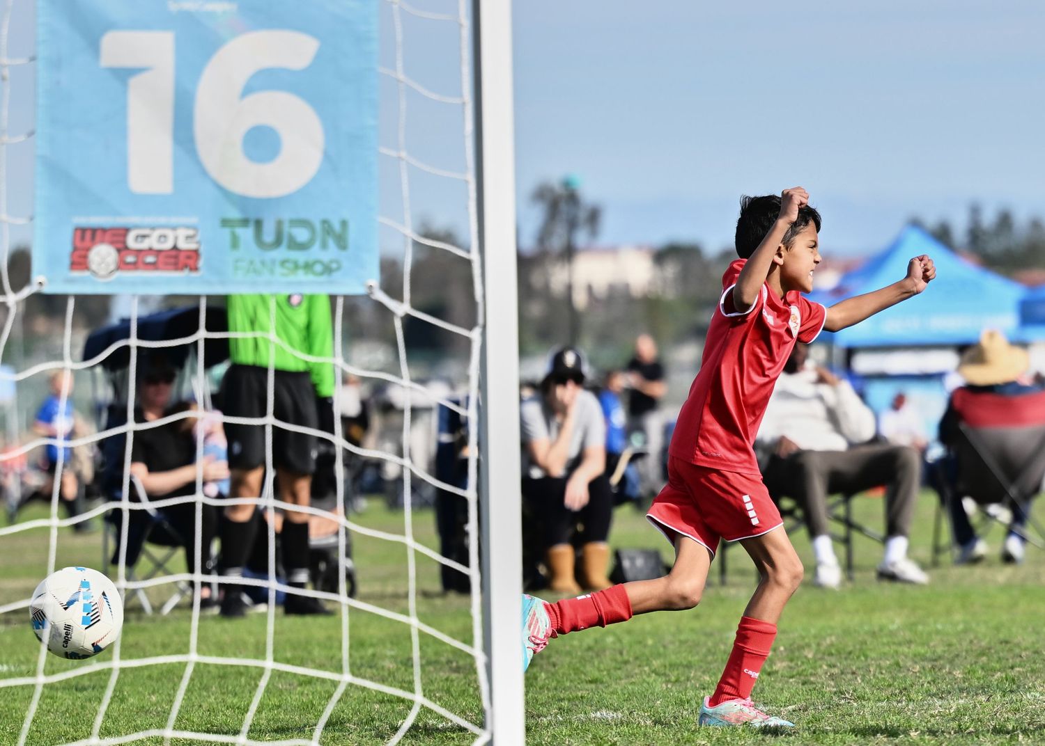 Soccer game sequence showing goal attempt and save at youth sports field.