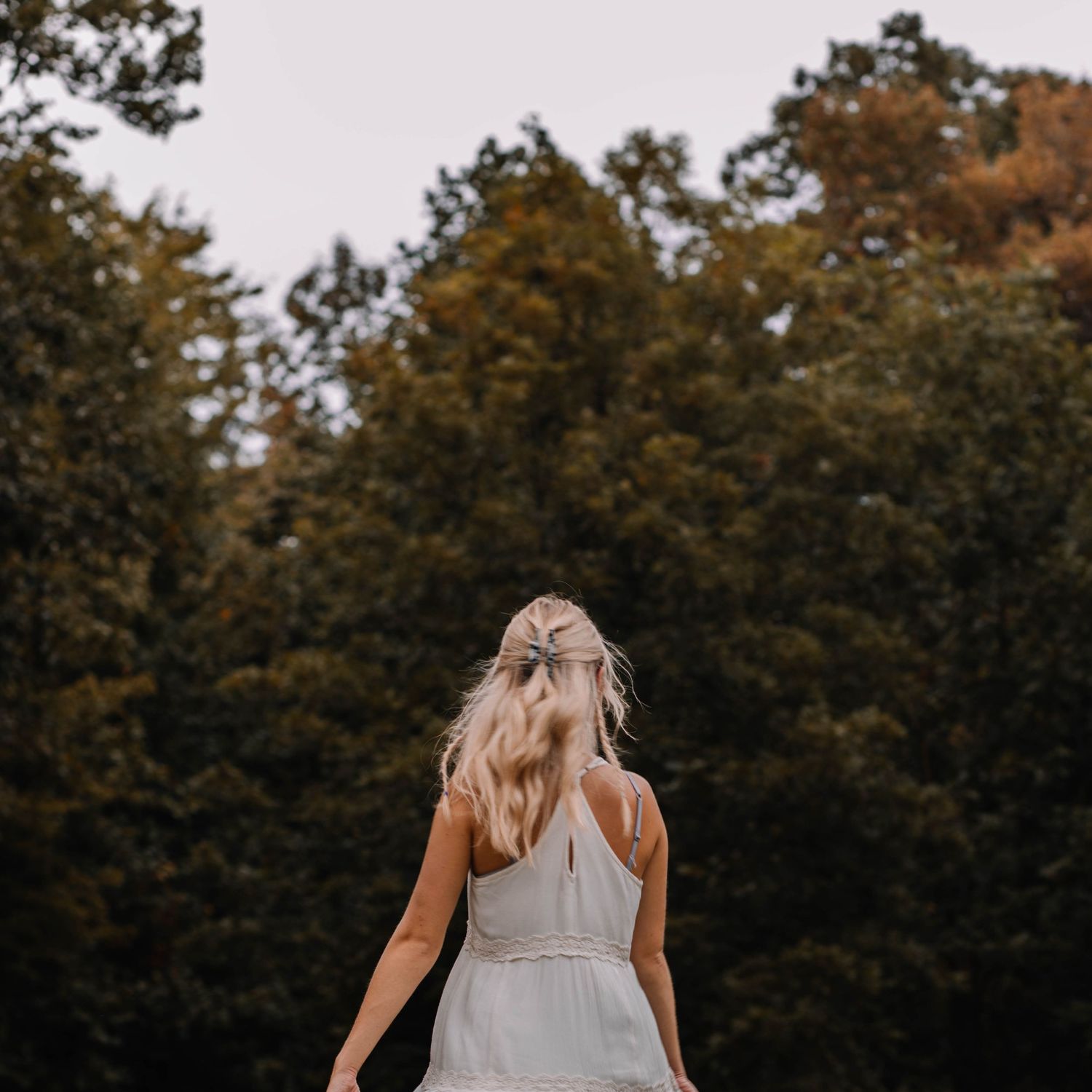 Motion blurred image of a girl in a white dress running towards the trees, estill county kentucky