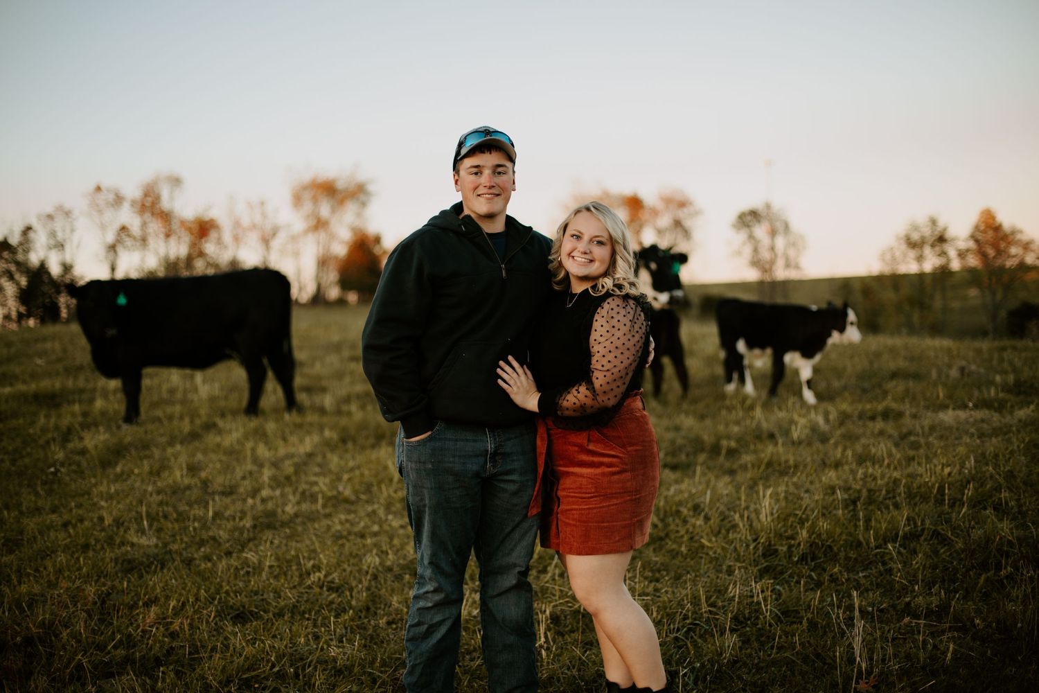 Young couple smiling in a field with cows, sunset, dry ridge kentucky