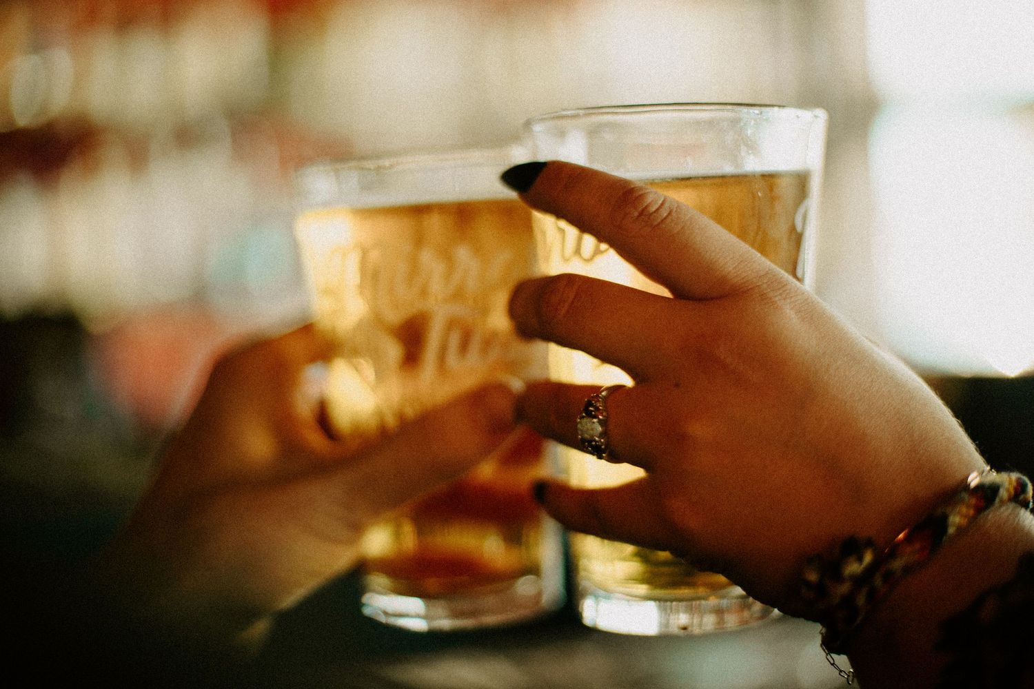 Newly married couple clink their pints of beer