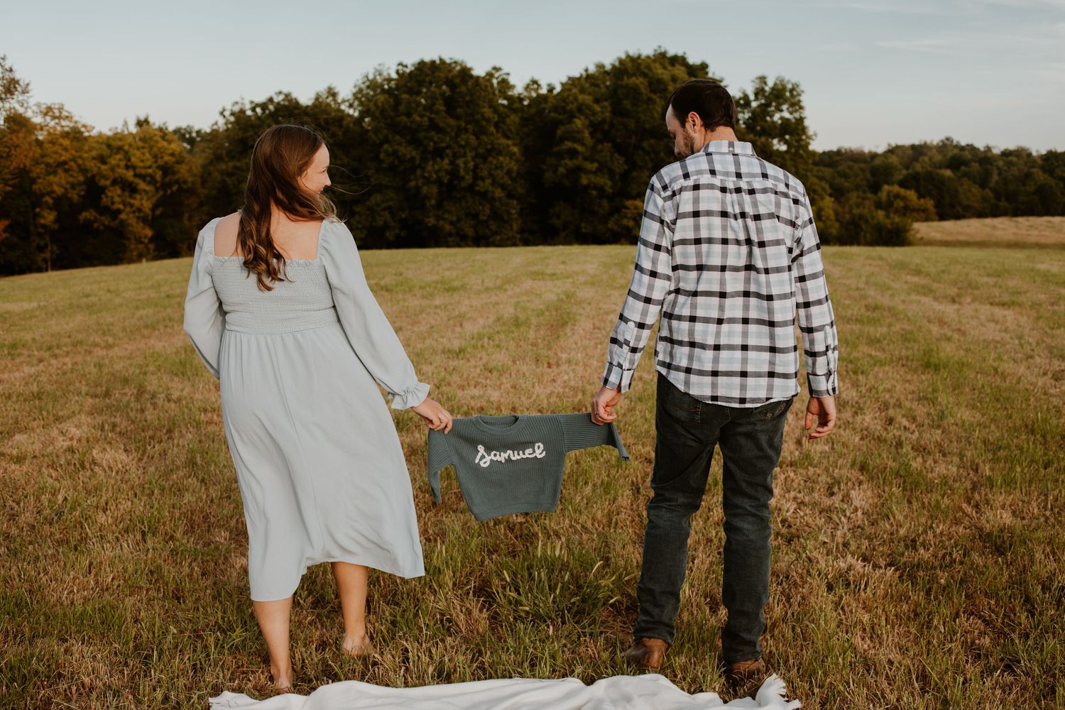 Expecting couple walking with new baby's sweater, maternity photo, shelbyville