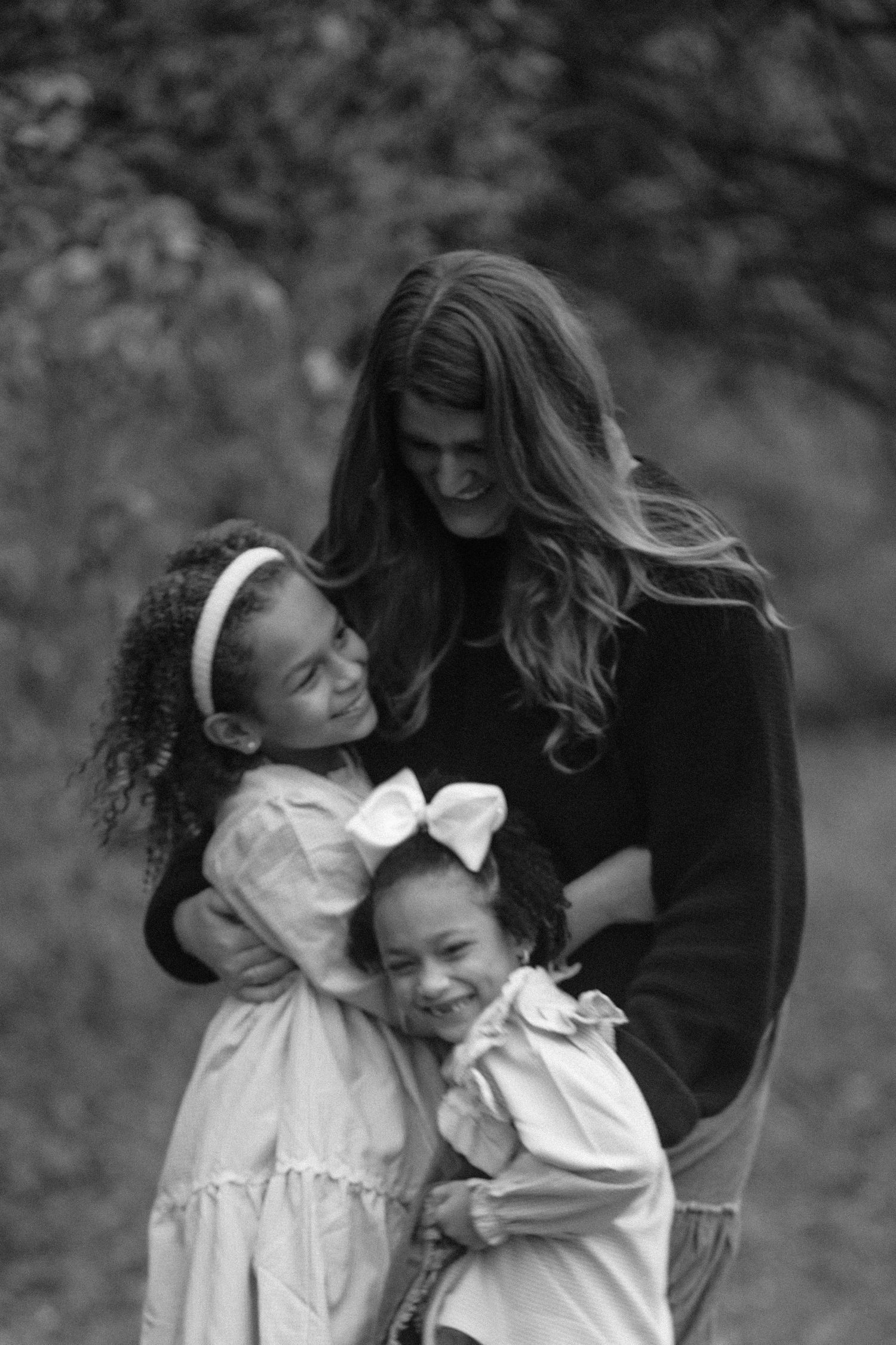 Black and white image of a girl and her young nieces smiling