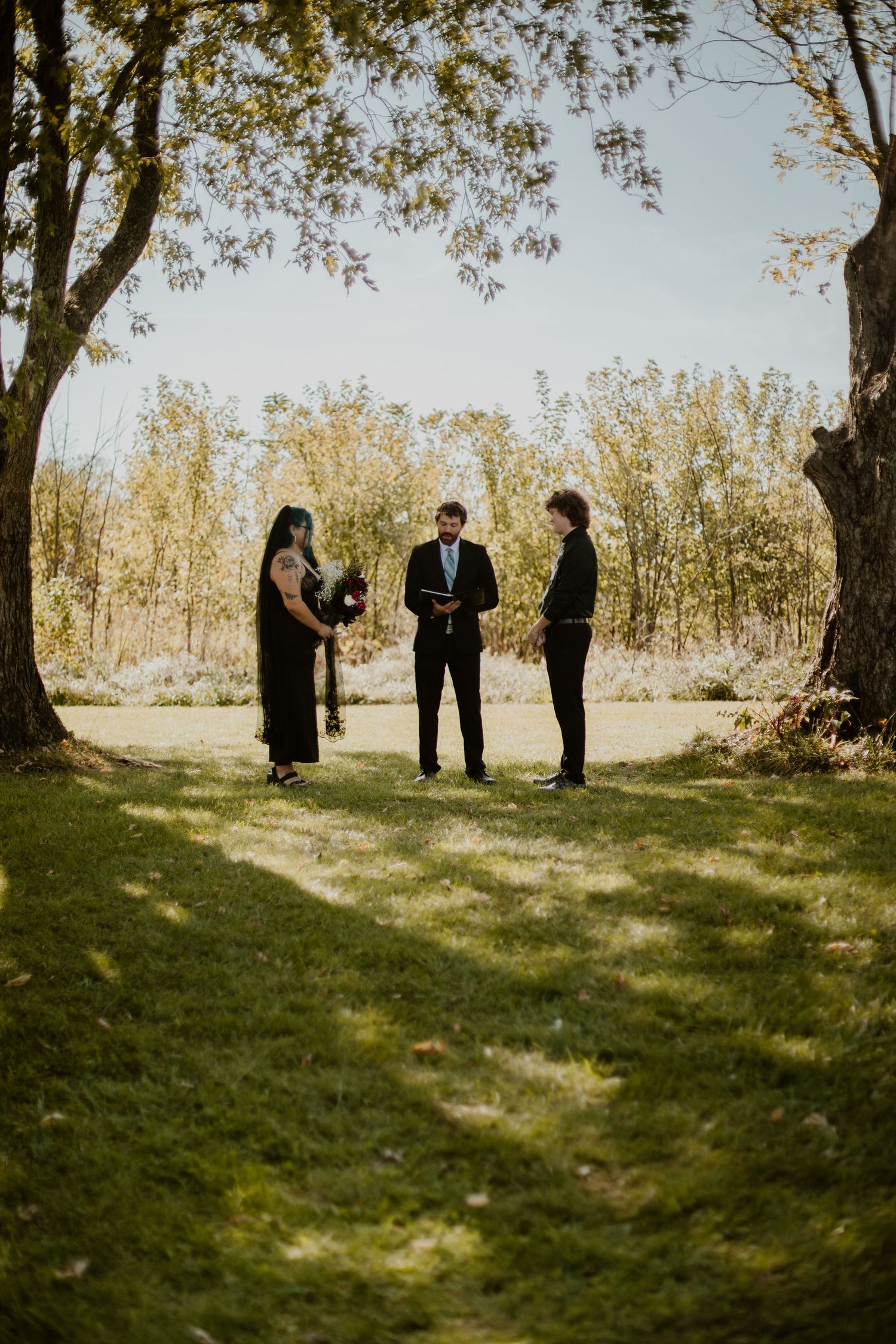 Bride, groom, and officiant are standing in the distance between two trees, Richmond photographer, rachel gorth, armory photography