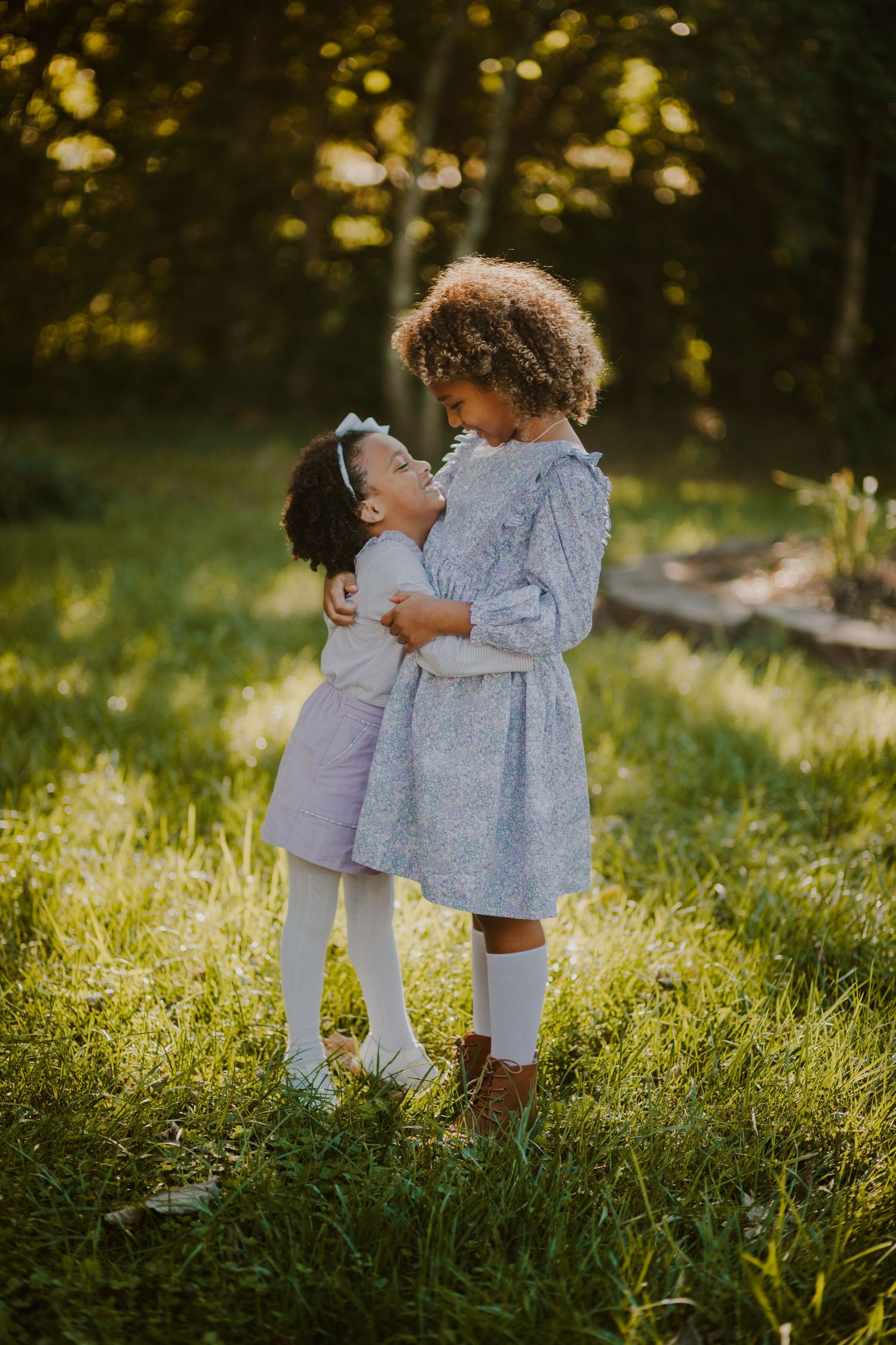 Two young sisters smiling and hugging on a spring day, lexington ky