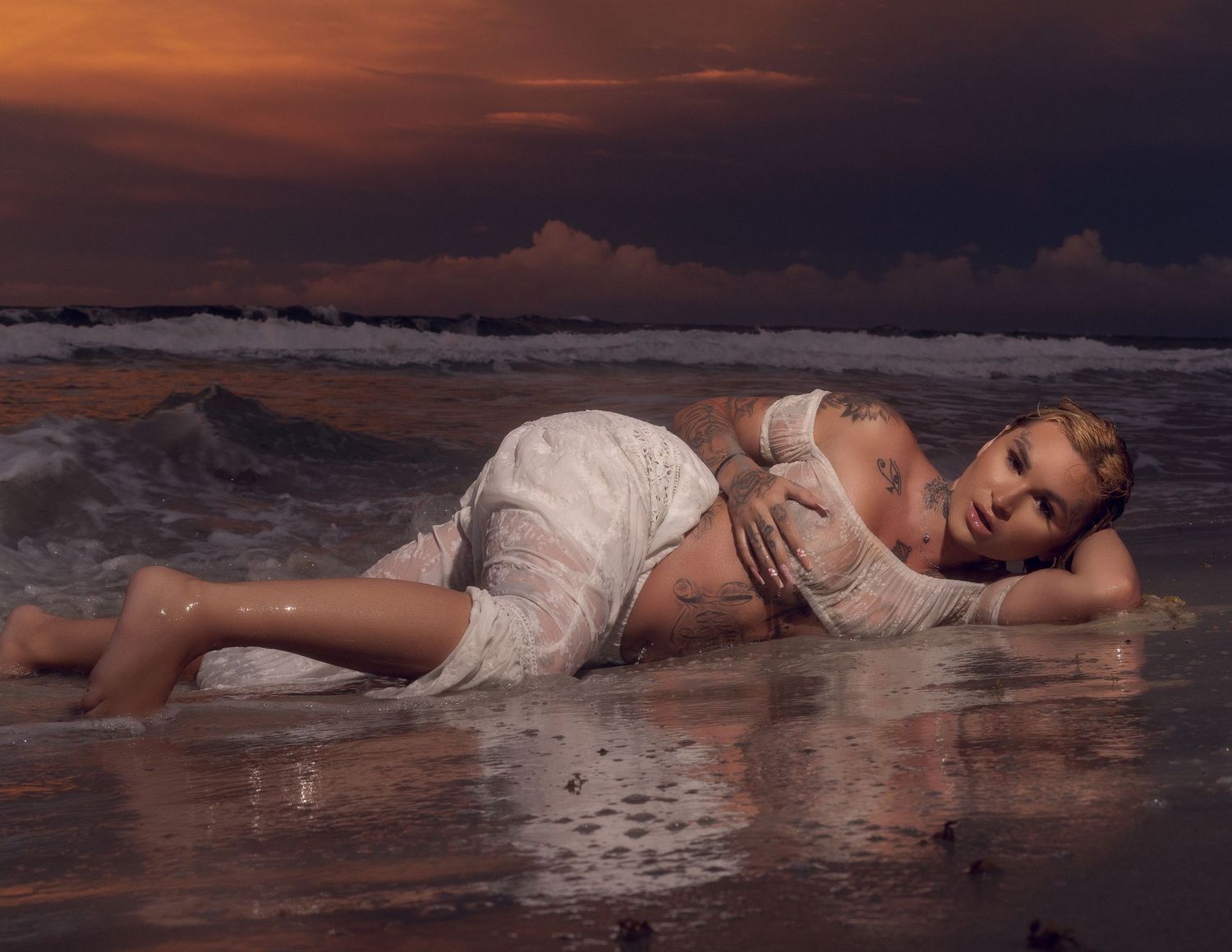 Sunset beach photoshoot with waves and warm golden lighting.