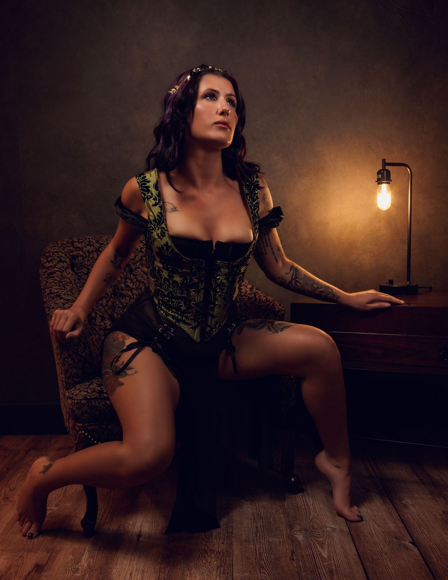 Vintage style boudoir portrait with green corset and warm lighting.