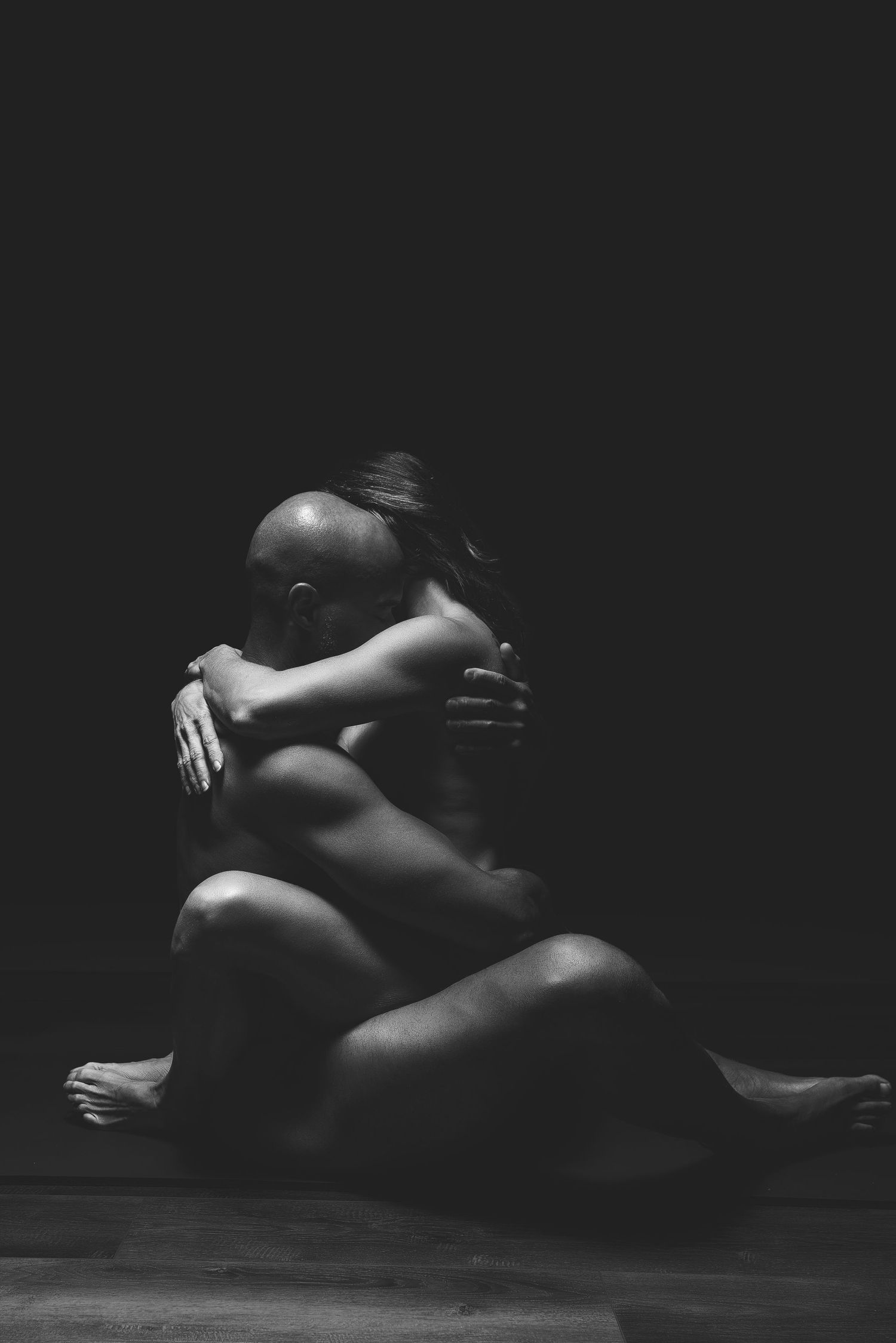 Artistic black and white nude figure study with dramatic shadows.