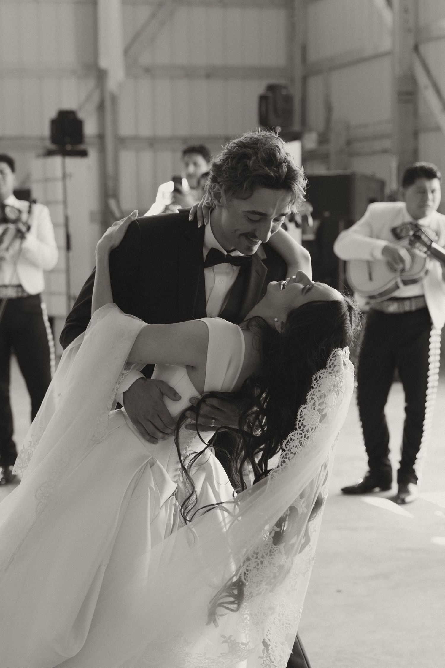Romantic black and white dance scene at an indoor wedding reception.