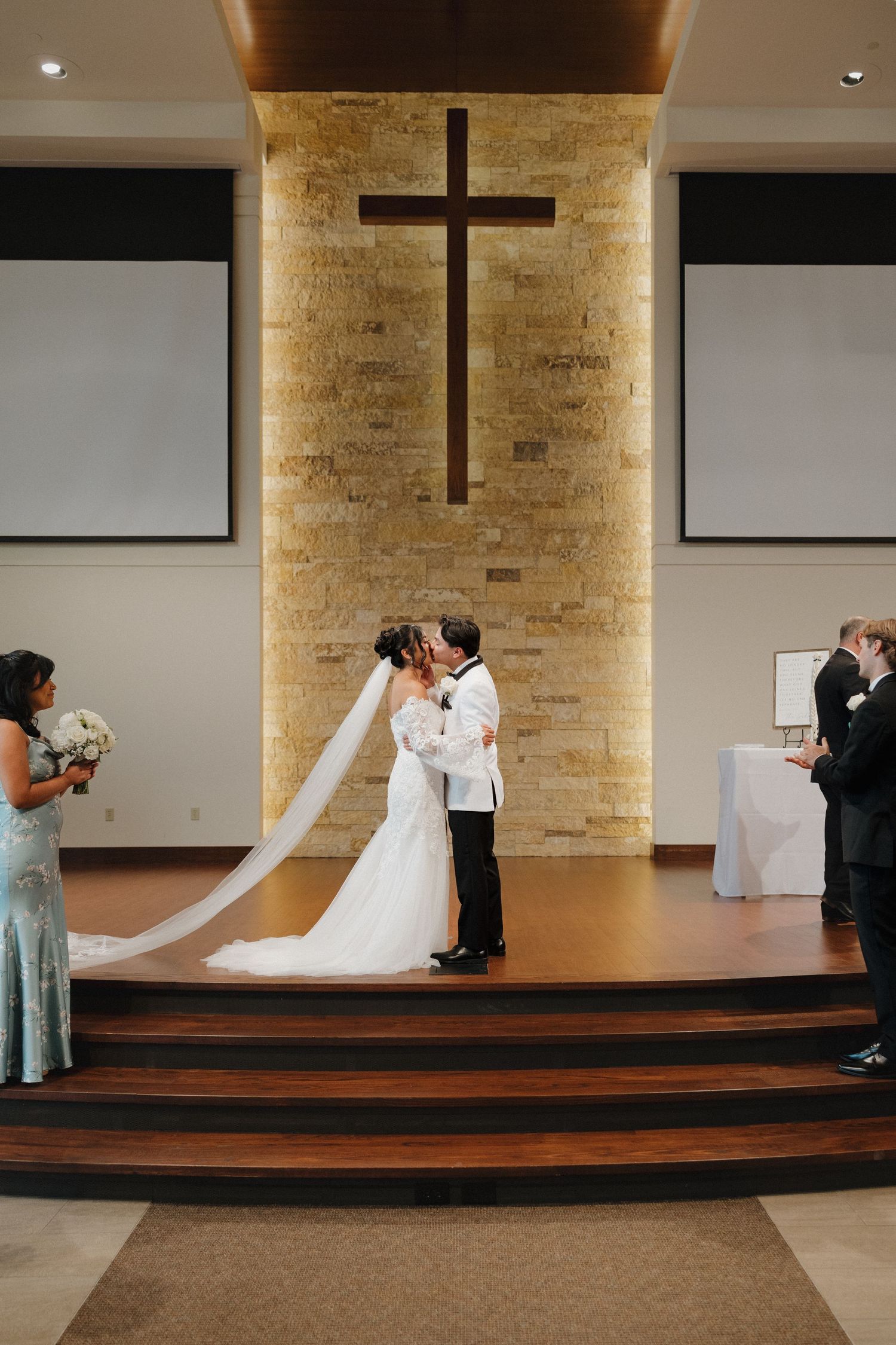 A sequence of four photos showing a wedding ceremony progression on a stage with exposed brick walls and screens.