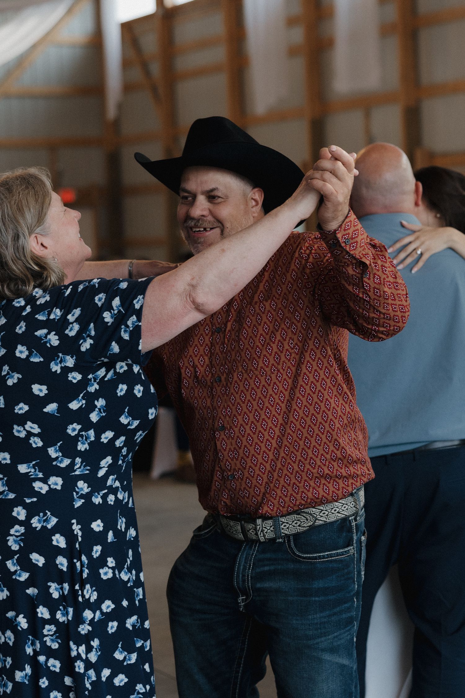 Couples dancing together at a country western style event with casual attire.